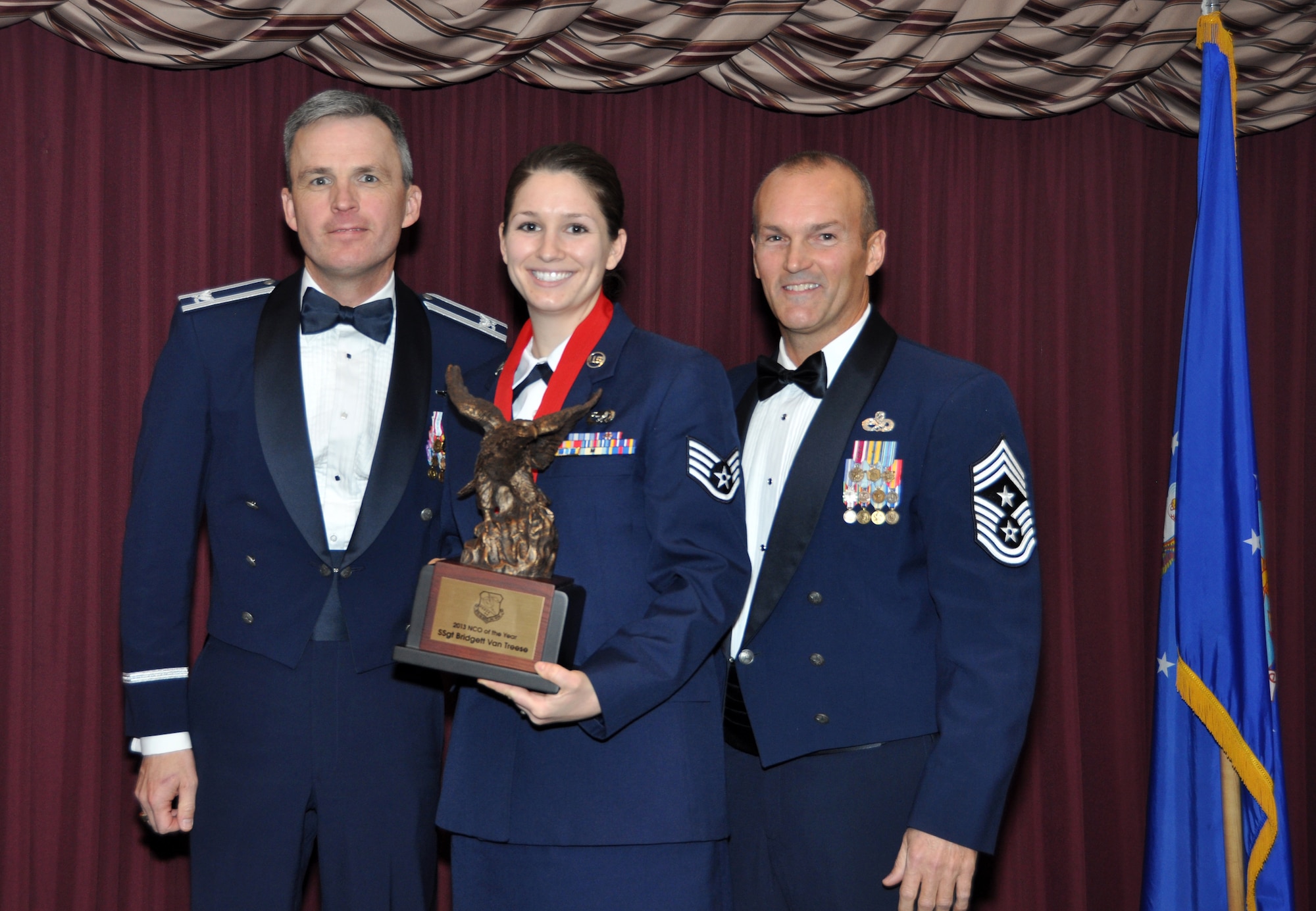 Staff Sgt. Bridget Van Treese receives the Non-Commissioned Officer of the Year Award from 507th Air Refueling Wing acting Commander, Col. Kevin Trayer, left and 507th ARW Command Chief, Chief Master Sgt. Steven Brown during the annual awards banquet at the Tinker club Nov. 23, 2013.  (U.S. Air Force photo/Senior Airman Mark Hybers)