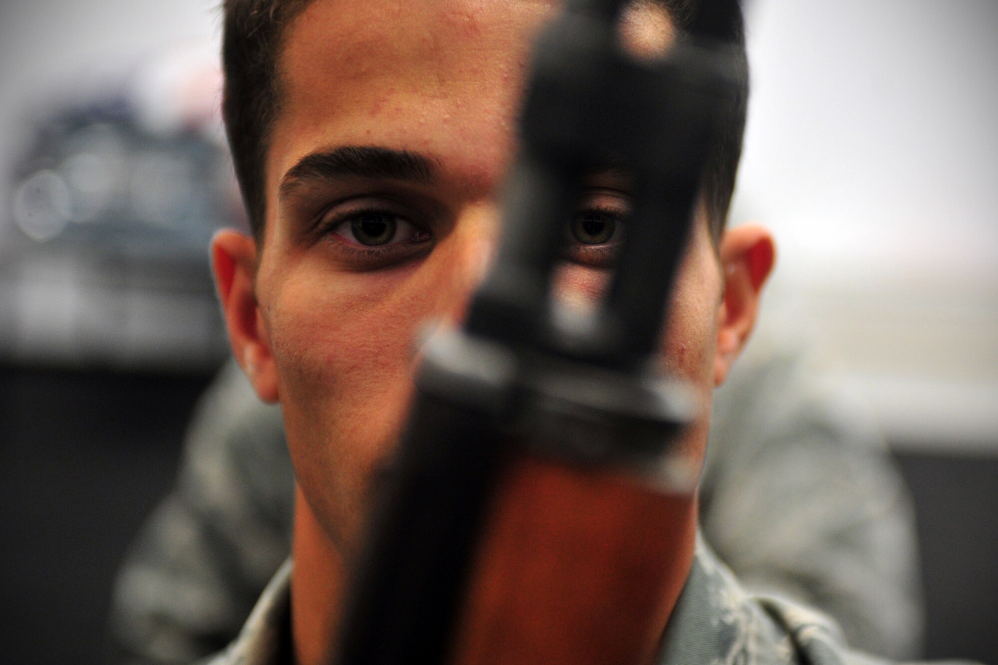 Airmen 1st Class Mostafa Mostafa, ceremonial guardsman, practices drills with a rifle during honor guard training at Fairchild Air Force Base, Wash., Nov. 25, 2013. Airmen display the position of port arms during training. (U.S. Air Force photo by Senior Airman Taylor Curry/Released)