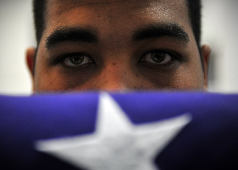 Airman 1st Class Miguel Medina, ceremonial guardsman, displays the proper way to fold a flag during honor guard training at Fairchild Air Force Base, Wash., Nov. 25, 2013. Prior to a ceremony, Airmen practice their technique multiple times to ensure they are prepared for the live ceremony. (U.S. Air Force photo by Senior Airman Taylor Curry/Released)