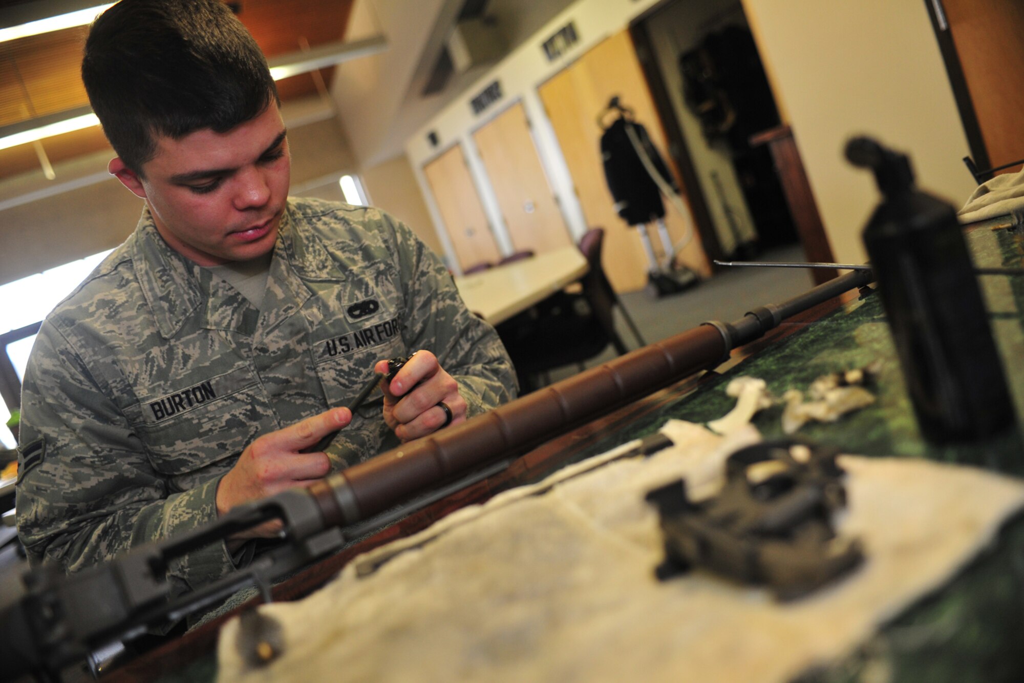 Airman 1st Class Anthony Burton, ceremonial guardsman with base honor guard, disassembles and cleans rifles at Fairchild Air Force Base, Wash., Nov. 25, 2013. Routine weapon maintenance insures the weapons fire correctly during ceremonies. (U.S. Air Force photo by Senior Airman Taylor Curry/Released)