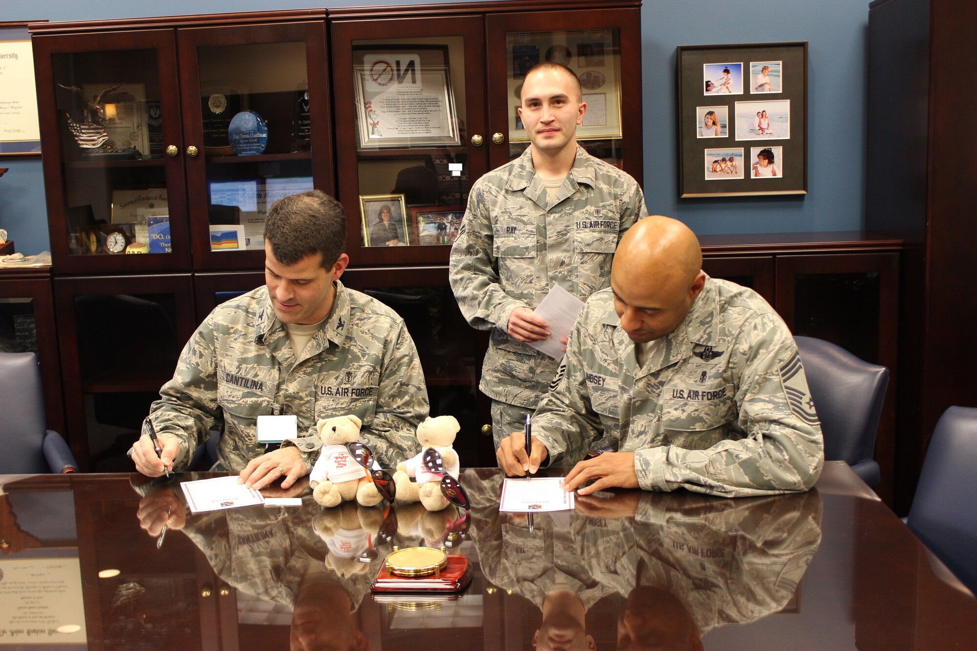 Col. Thomas Cantilina, 779th Medical Group Commander, and Chief Master Sgt. Rodney Lindsey, 779th MDG superintendent, sign their National Drunk and Drugged Driving Prevention (3D) pledge cards as Airman 1st Class Colby Ray, Alcohol and Drug Abuse Prevention and Treatment program mental health technician, watches at Joint Base Andrews, Md. Signing the 3D card is an agreement to never drive under the influence, never ride with an impaired driver to always wear a seat belt. National 3D Month ran from Dec. 1-31, 2013. (Courtesy photo) 