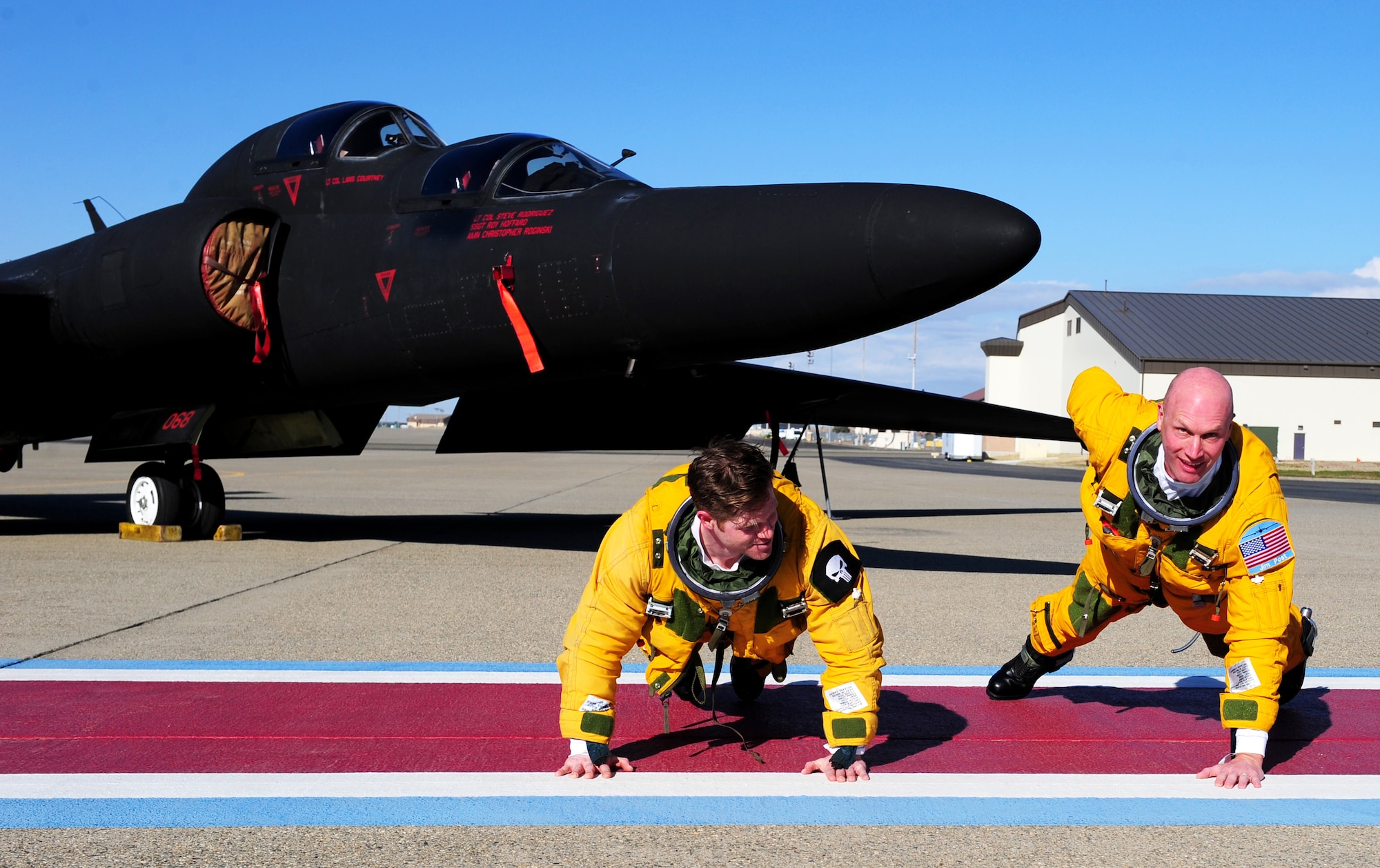 Maj. Gen.  James N. Post III, Air Combat Command director of operations (right), demonstrates a one armed push-up alongside Maj. Geoffrey, 1st Reconnaissance Squadron U-2 pilot, Dec, 3, 2013, at Beale Air Force Base Calif. Post and Geoffrey recently completed a sortie aboard a TU-2S. (U.S. Air Force photo by Airman 1st Class Bobby Cummings/Released)