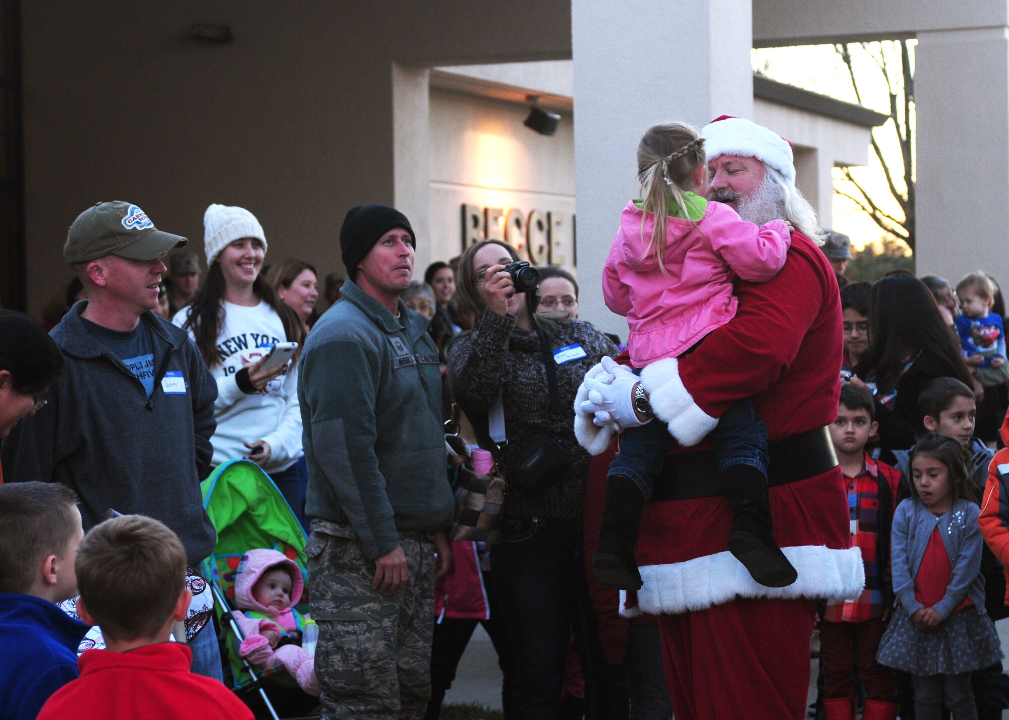 Santa Claus arrives on a fire engine and is greeted by children from Beale Air Force Base, Calif., during the Hearts Apart Dinner and tree lighting Dec. 4, 2013. The 9th Force Support Squadrons and Airman & Family Readiness Center  together with Beale's first sergeants, firefighters, and volunteers from the base hosted the tree lighting for the base populace and the Hearts Apart Dinner for spouses and families of deployed Airmen. (U.S. Air Force photo by Senior Airman Allen Pollard/Released)