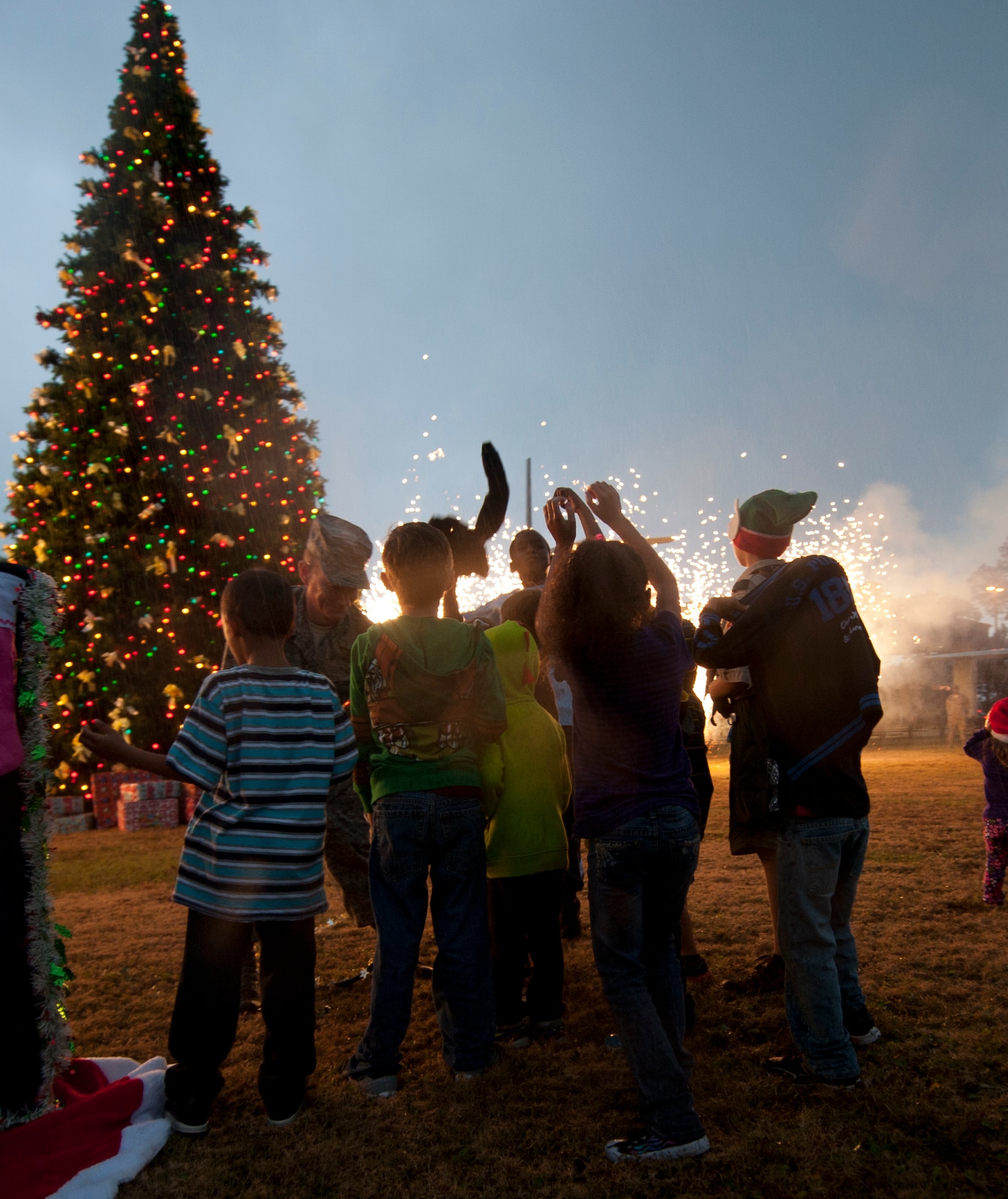 Children assist Col. William West, 1st Special Operations Wing commander, with pulling the switch to activate the lights during the holiday tree lighting ceremony at the Air Park on Hurlburt Field, Fla., Dec. 4, 2013. The ceremony also included pyrotechnics. (U.S. Air Force photo/Senior Airman Krystal M. Garrett)