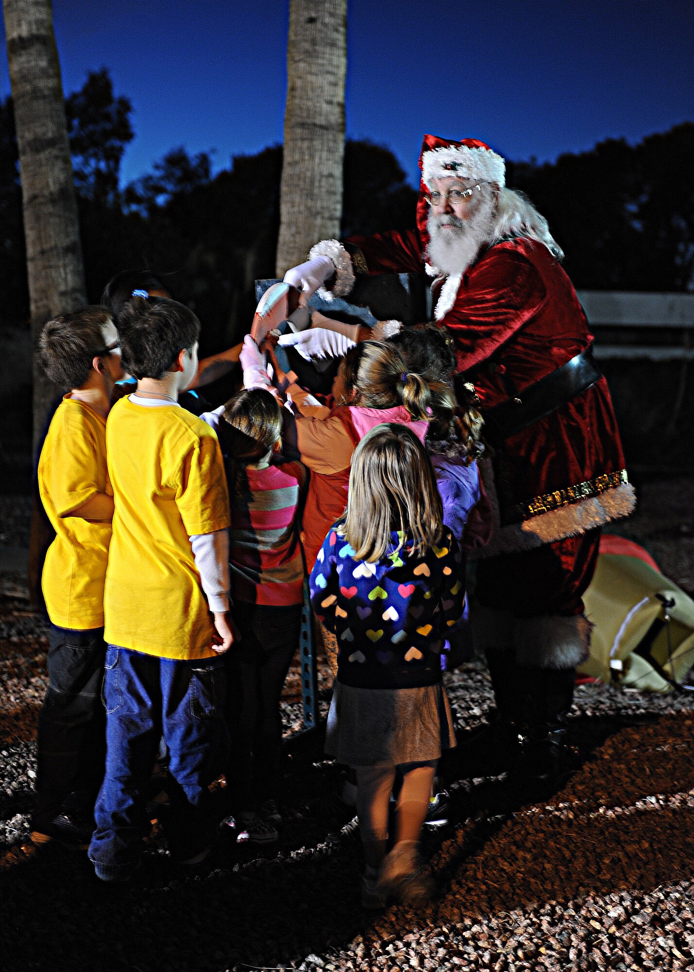 Children of deployed Airmen assist Santa Claus in flipping the switch that lights up the base Christmas tree during the ?Starry, Snowy, Southwest Night? event at Davis-Monthan Air Force Base, Ariz., Dec. 3, 2013.  The event gave D-M members a taste of winter with snow and ice skating activities. (U.S. Air Force photo by Airman 1st Class Chris Massey/Released)