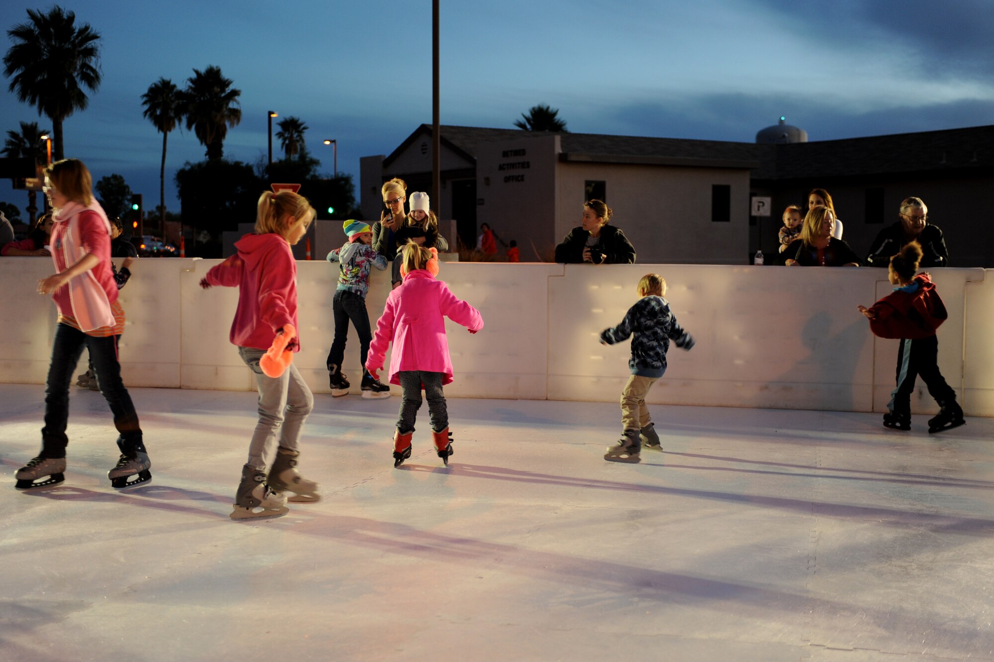 Members of the base skate around an ice rink during the ?Starry, Snowy, Southwest Night? event at Davis-Monthan Air Force Base, Ariz., Dec. 3, 2013.  The event provided a winter experience for families of the base who would normally miss out due to Arizona?s typically warm weather. (U.S. Air Force photo by Airman 1st Class Chris Massey/Released)
