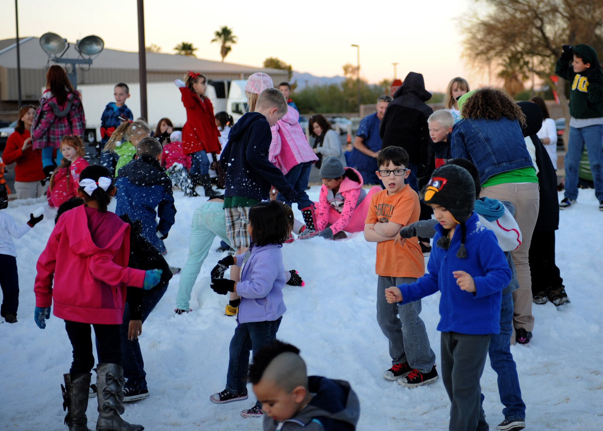 People attending the ?Starry, Snowy, Southwest Night? event play in the snow at Davis-Monthan Air Force Base, Ariz., Dec. 3, 2013.  Fifty tons of snow was made for the event that brought out approximately 2,200 people. (U.S. Air Force photo by Airman 1st Class Chris Massey/Released)