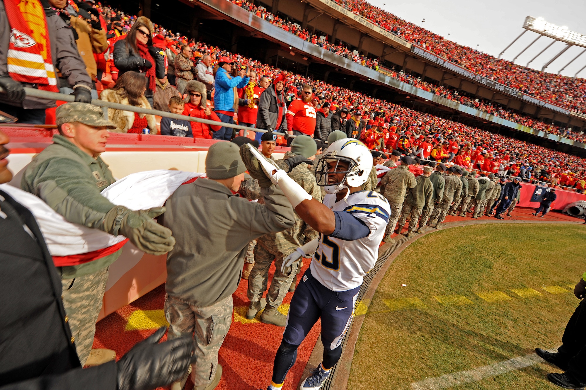 Darrell Stuckey, San Diego Chargers strong safety, high-fives Airmen from the 509th Bomb Wing, Whiteman Air Force Base Mo., during the pre-game ceremony of a military appreciation game at Arrowhead Stadium in Kansas City, Mo., Nov. 24, 2013. As a Kansas City resident, Stuckey was a fourth-round draft pick in 2012 and has been one of the National Football League’s top special teams performers for four years. (U.S. Air Force photo by Staff Sgt. Nick Wilson/Released)