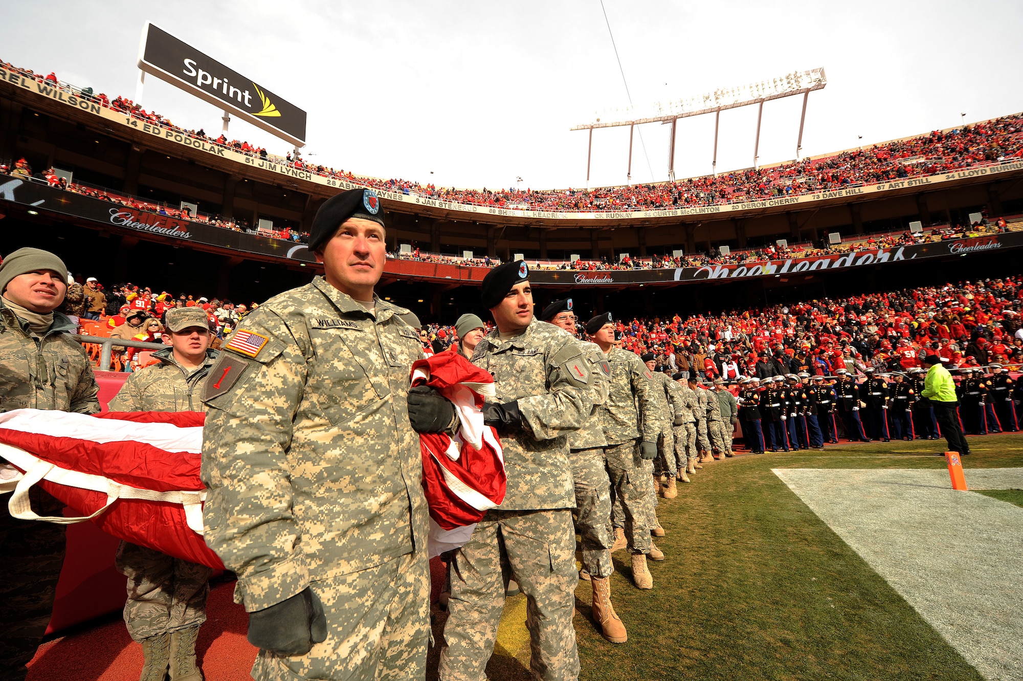 Service members hold the American flag during the pre-game ceremony of a military appreciation game at Arrowhead Stadium in Kansas City, Mo., Nov. 24, 2013.  Members of the U.S. military participate in ceremonies at various sporting events to increase military interest, stir patriotism and recruit future Service members. (U.S. Air Force photo by Staff Sgt. Nick Wilson/Released)