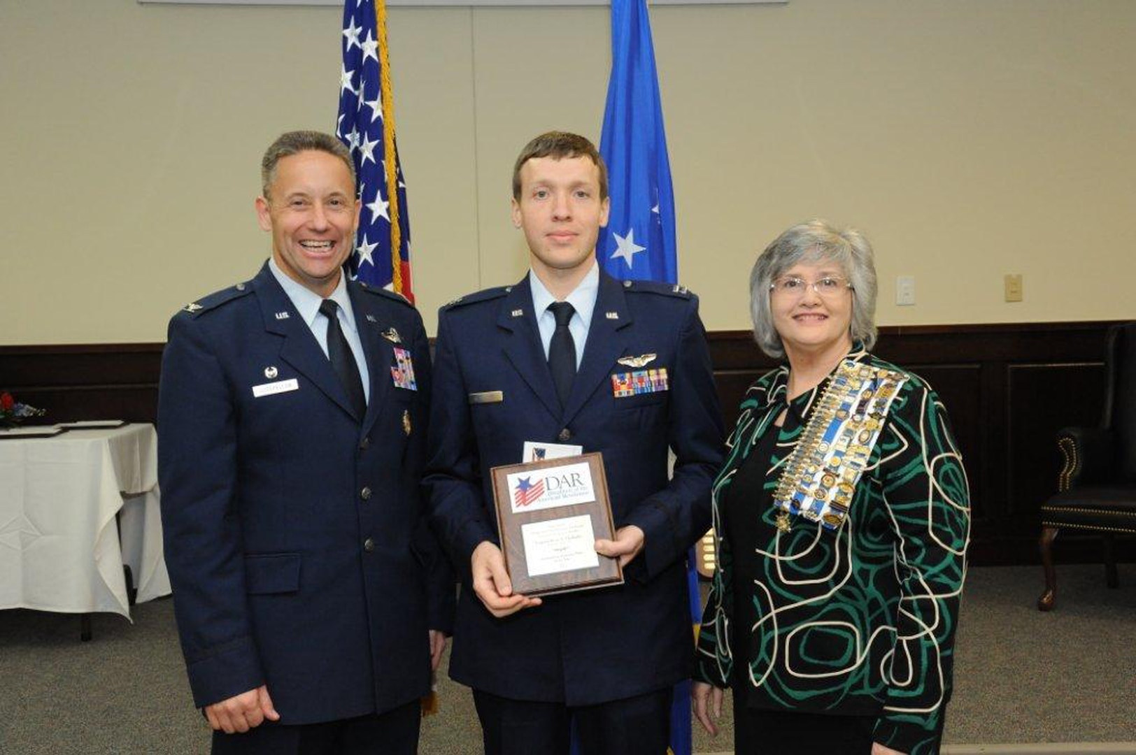 Col. Gerald Goodfellow (left), 12th Flying Training Wing commander, Joint Base San Antonio-Randolph, and Susan Green Tillman (center right), State Recording Secretary of Texas, Daughters of the American Revolution, present Capt. Brian Thalhofer with the Instructor Pilot of the Year Award. (U.S. Air Force photo by Rich McFadden)