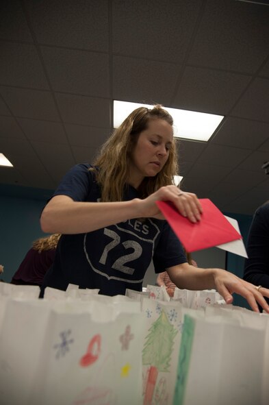 Natalie Price, spouse of U.S. Air Force Lt. Col. Stephen Price, adds holiday cards to cookie packages at Moody Air Force Base, Ga., Dec. 4, 2013. Members of local churches donated and signed the cards. (U.S. Air Force Photo by Airman 1st Class Sandra Marrero/Released)
