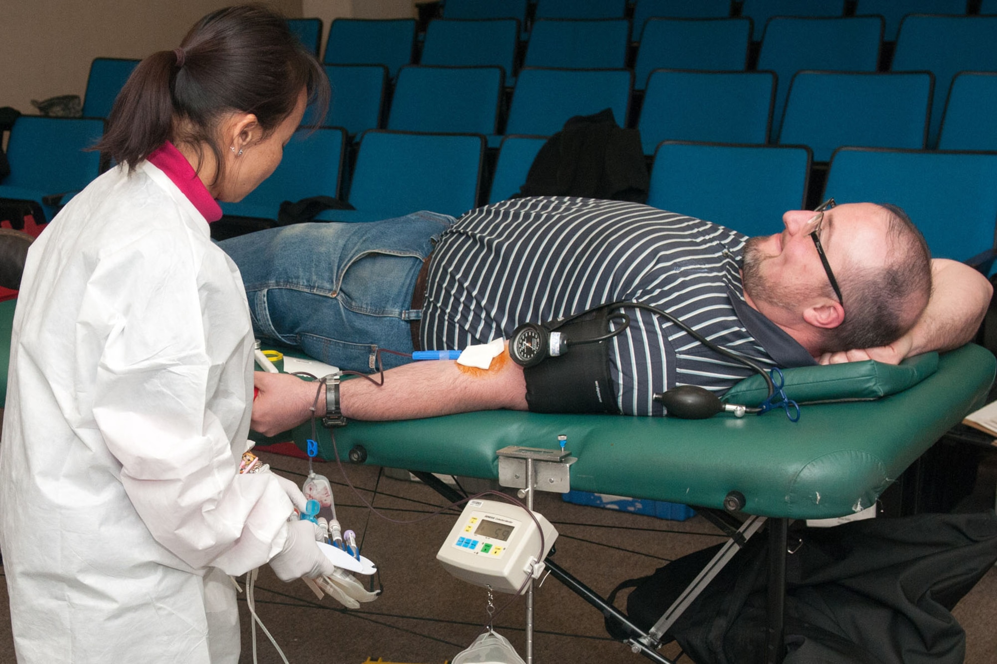 HANSCOM AIR FORCE BASE, Mass. – Sopheata Pan (left), a Red Cross staff member, draws blood from Mike Bourgeois at the Hanscom Conference Center during a recent Red Cross Blood Drive, Dec. 3. Hanscom collects more than 100 units during a usual two-day blood drive on base. For more information on donating blood through the Red Cross, visit redcross.org/donate/give. (U.S. Air Force photo by Rick Berry)