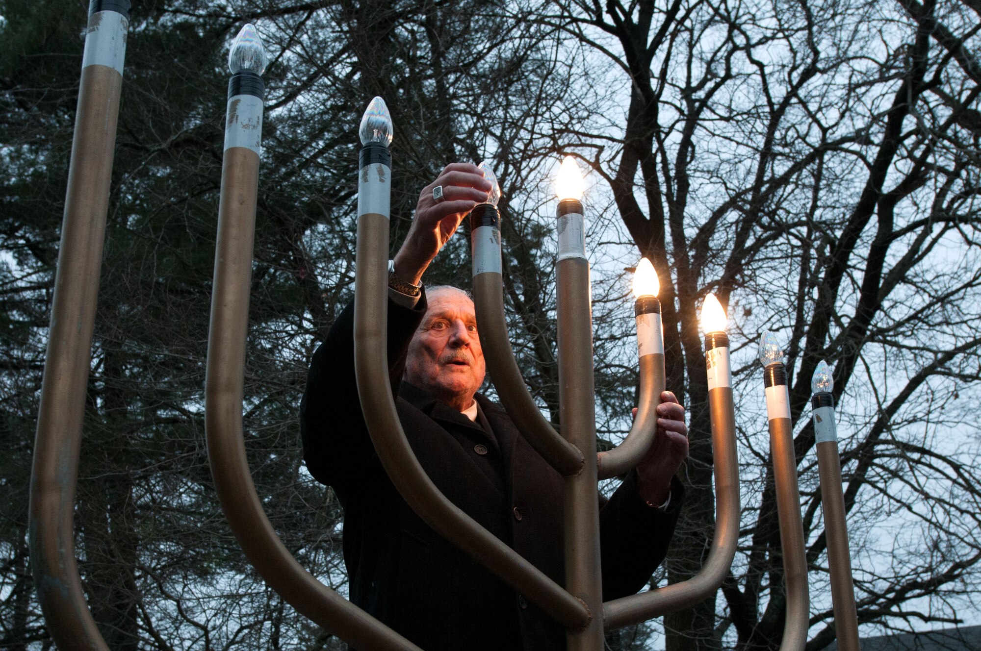 HANSCOM AIR FORCE BASE, Mass. -- Rabbi Abraham Morhaim lights the Menorah as members of the Hanscom Jewish community gather Dec. 2 at the Base Chapel to observe Hanukkah. Hanukkah lasts for eight days and nights. (U.S. Air Force photo by Mark Herlihy)