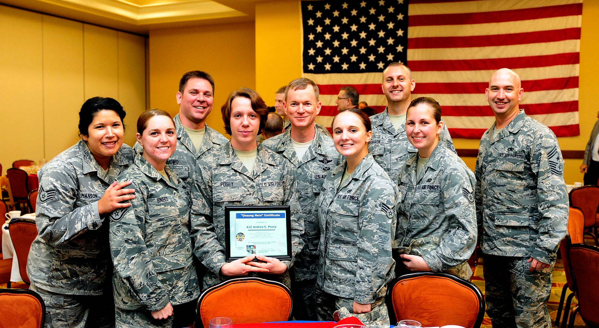 Col. William West (center), 1st Special Operations Wing commander, and Chief Master Sgt. Jefferey Maberry (far right), 1st SOW command chief, pose with an unsung hero award winner and her unit at the Soundside Club on Hurlburt Field, Fla., Dec. 4, 2013. The unsung hero award highlights outstanding performers who have not been previously recognized. (U.S. Air Force photo/Staff Sgt. Jeff Andrejcik)