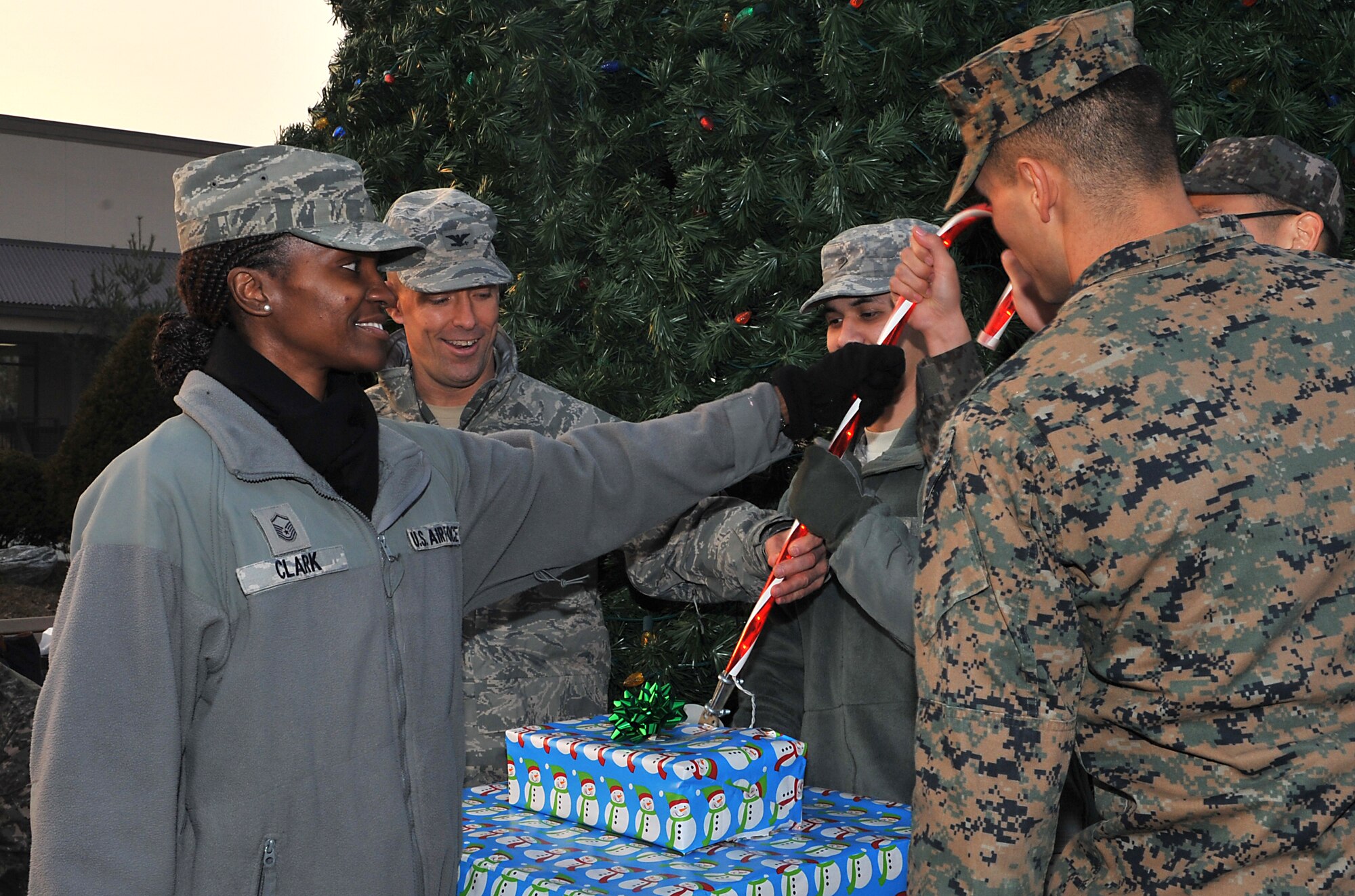 Representatives of Team Osan help Col. Brook Leonard, 51st Fighter Wing commander, pull the switch to light up the Christmas tree during the lighting ceremony at Osan Air Base, Republic of Korea, Dec. 4, 2013. An Airman, Marine, Soldier and ROK air force Airman were chosen to illustrate the joint nature of the base. (U.S. Air Force photo/Airman 1st Class Ashley J. Thum)