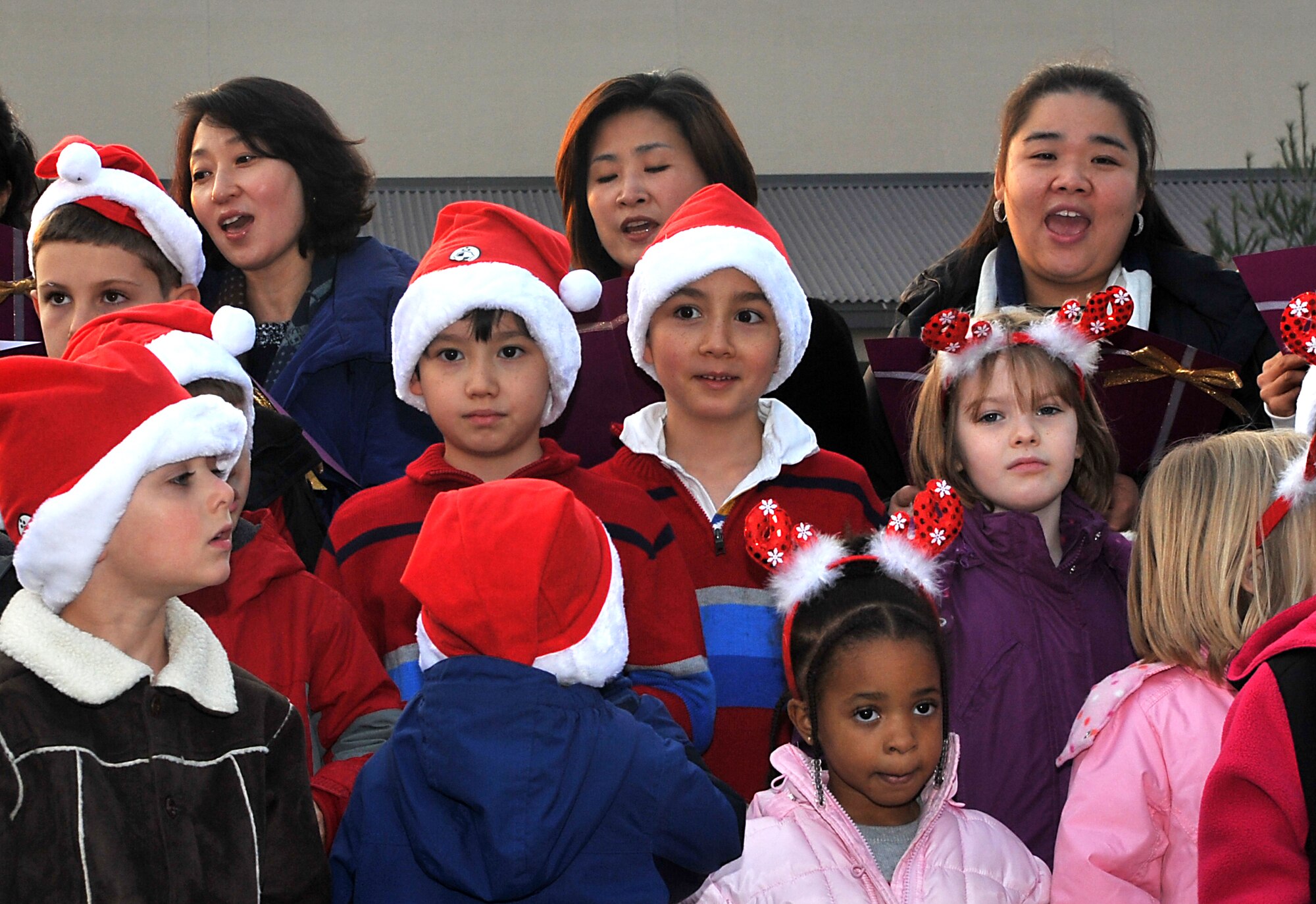 Members of the Republic of Korea air force choir sing traditional Christmas carols in their native language during the Christmas tree lighting ceremony at Osan Air Base, Republic of Korea, Dec. 4, 2013. Hundreds of service members and their families gathered in the “Main Square” in front of the base theater to witness the lighting of the tree. (U.S. Air Force photo/Airman 1st Class Ashley J. Thum)