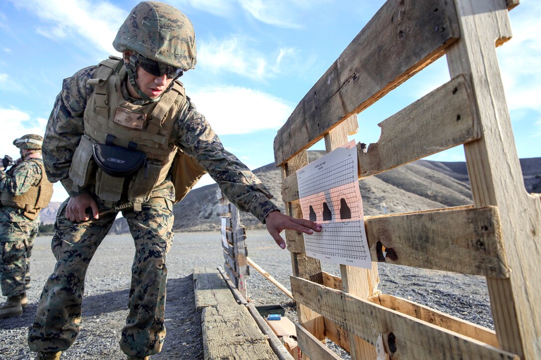 Marine Corps Cpl. Richard Hernandez makes calculations to a target to help a Marine attain his battle sight zero during a small-arms training exercise on Camp Pendleton, Calif., Nov. 25, 2013. Hernandez, a data network specialist, is assigned to 15th Marine Expeditionary Unit.