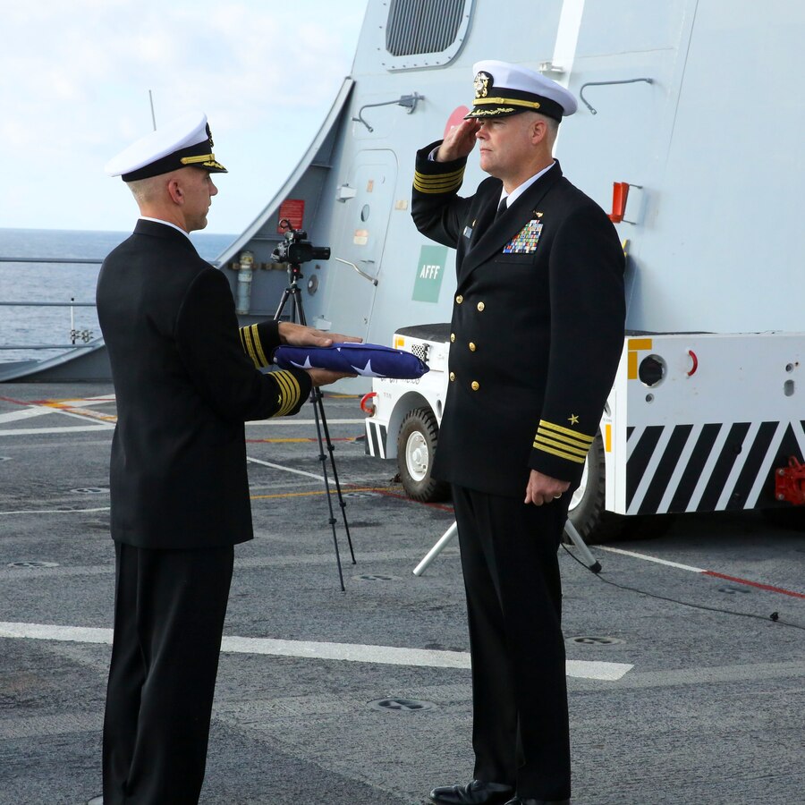 USS NEW YORK- The USS New York’s Commanding Officer Captain Jon Kreitz renders a salute as the ships Executive Officer Captain Christopher Brunett presents a flag in memory of the 20 Marines and Sailors the USS New York paid tribute to on December 5, 2013.  The USS New York is on its way to its new home port, Jacksonville, Fla.