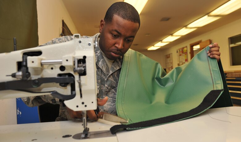 Staff Sgt. Nickolas Hill cuts excess velcro from an air deflector , Dec. 3, 2013, at the 379th Air Expeditionary Wing, Southwest Asia. Hill helped create 44 air deflectors which are used on air conditioners that cool a variety of aircraft. Creating the air deflectors saved production time, time to order and ship, and maintenance dollars. Hill is the 379th Expeditionary Operations Support Squadron aircraft flight equipment back shop assistant NCO in charge. (U.S. Air Force photo/Master Sgt. David Miller)