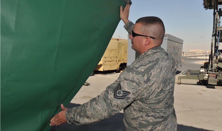 Tech. Sgt. Andrew Wahlin attaches an air deflector to an air conditioning unit Dec. 3, 2013, at the 379th Air Expeditionary Wing, Southwest Asia. Wahlin helped create 44 air deflectors which are used on air conditioners that cool a variety of aircraft. Creating the air deflectors saved production time, time to order and ship, and maintenance dollars. Wahlin is the 379th Expeditionary Operations Support Squadron aircraft flight equipment back shop NCO in charge. (U.S. Air Force photo/Master Sgt. David Miller)
