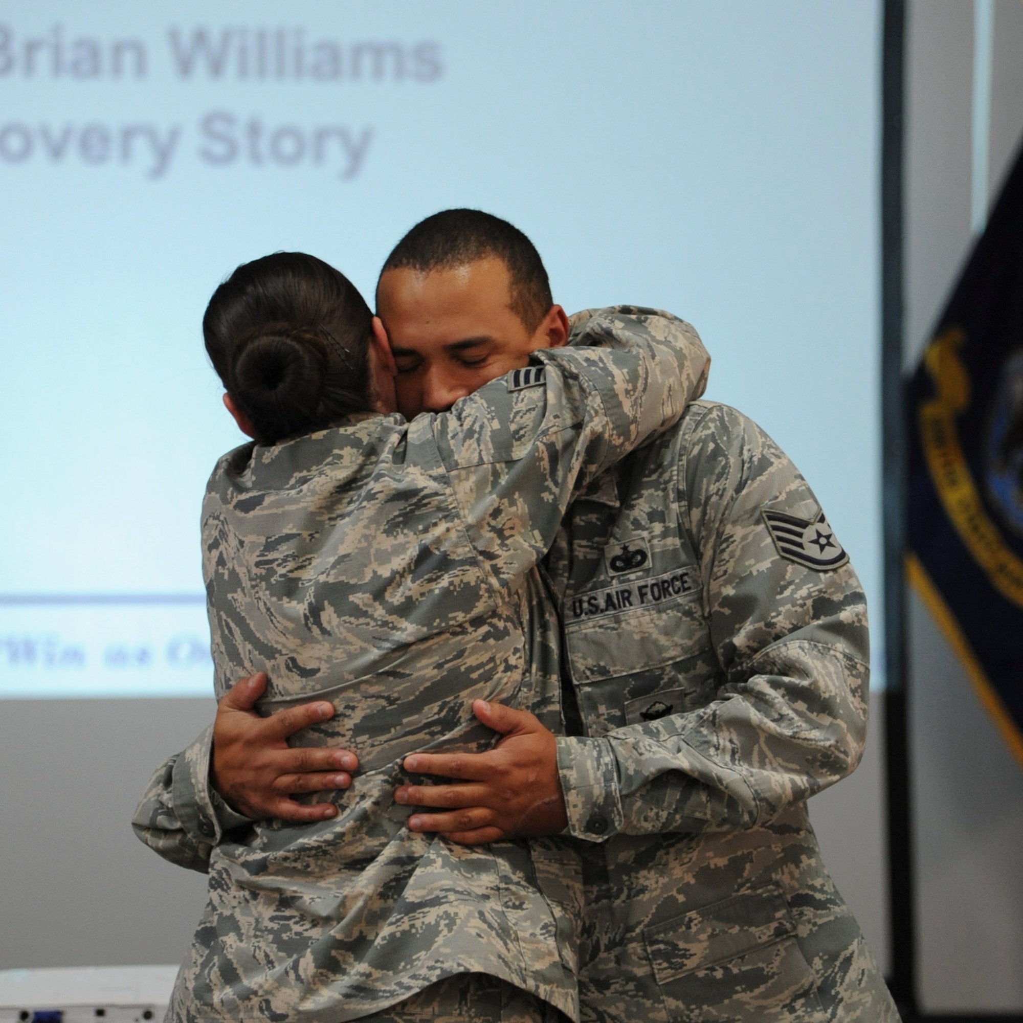 Staff Sgt. Brian Williams hugs his fiancée, Staff Sgt. Emily Christofaro, after finding out he received a promotion to technical sergeant Oct. 30, 2013, at the New Jersey National Guard Armory in Bordentown, N.J. Williams returned to duty after recovering from an improvised explosive device attack while deployed to Afghanistan. Williams is a 87th Security Forces Squadron military working dog handler. (U.S. Air Force photo by 1st Lt. Alexis McGee/Released)