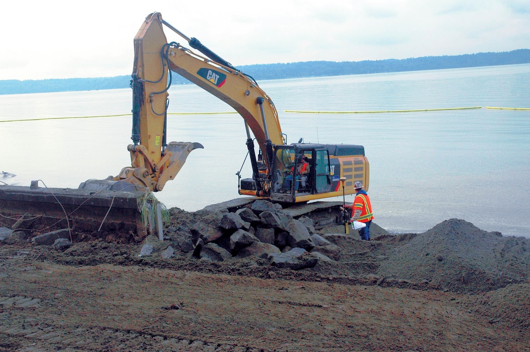 A trackhoe excavator equipped with a thumb grabs and removes bulkhead at Seahurst Park in Burien, Wash. The Seahurst Phase 2 project restores and reconnects 1,800 feet of forage fish nearshore habitat by removing the seawall and riprap along the beach. Improved habitat aids recovery of species, such as bull trout, steelhead and Chinook salmon, listed under the Endangered Species Act. Burien’s Seahurst Park provides a significant and unique restoration opportunity in the heart of Puget Sound. The 4,500 feet of shoreline make up the largest public shoreline park between Seattle and Tacoma.