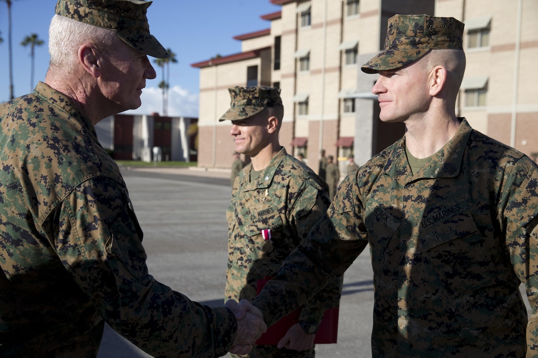 Lt. Gen. John A. Toolan, commanding general, I Marine Expeditionary Force, shakes hands with Sgt. Maj. Troy Black, the 11th Marine Expeditionary Unit sergeant major, to congratulate him and the 11th MEU for earning the Meritorious Unit Commendation award here Dec. 5. The 11th MEU was awarded a MUC for its actions in previous deployment. (Photo by: U.S. Marine Corps Cpl. Jonathan R. Waldman, Combat Camera, 11th Marine Expeditionary Unit)