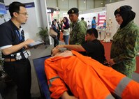 Royal Brunei Air Force members and their family members view a life-saving skills vendor exhibition during the fourth biennial Brunei Darussalam International Defense Exhibition at the BRIDEX Exhibition Center in Bandar Seri Begawan, Brunei, Dec. 5, 2013. BRIDEX 13 is an opportunity for networking and sharing technology with regional partners and allies which builds strong multilateral relationships, increases cooperation and enhances preparedness for disasters and other contingency operations. (U.S. Air Force photo/Master Sgt. Jerome S. Tayborn)