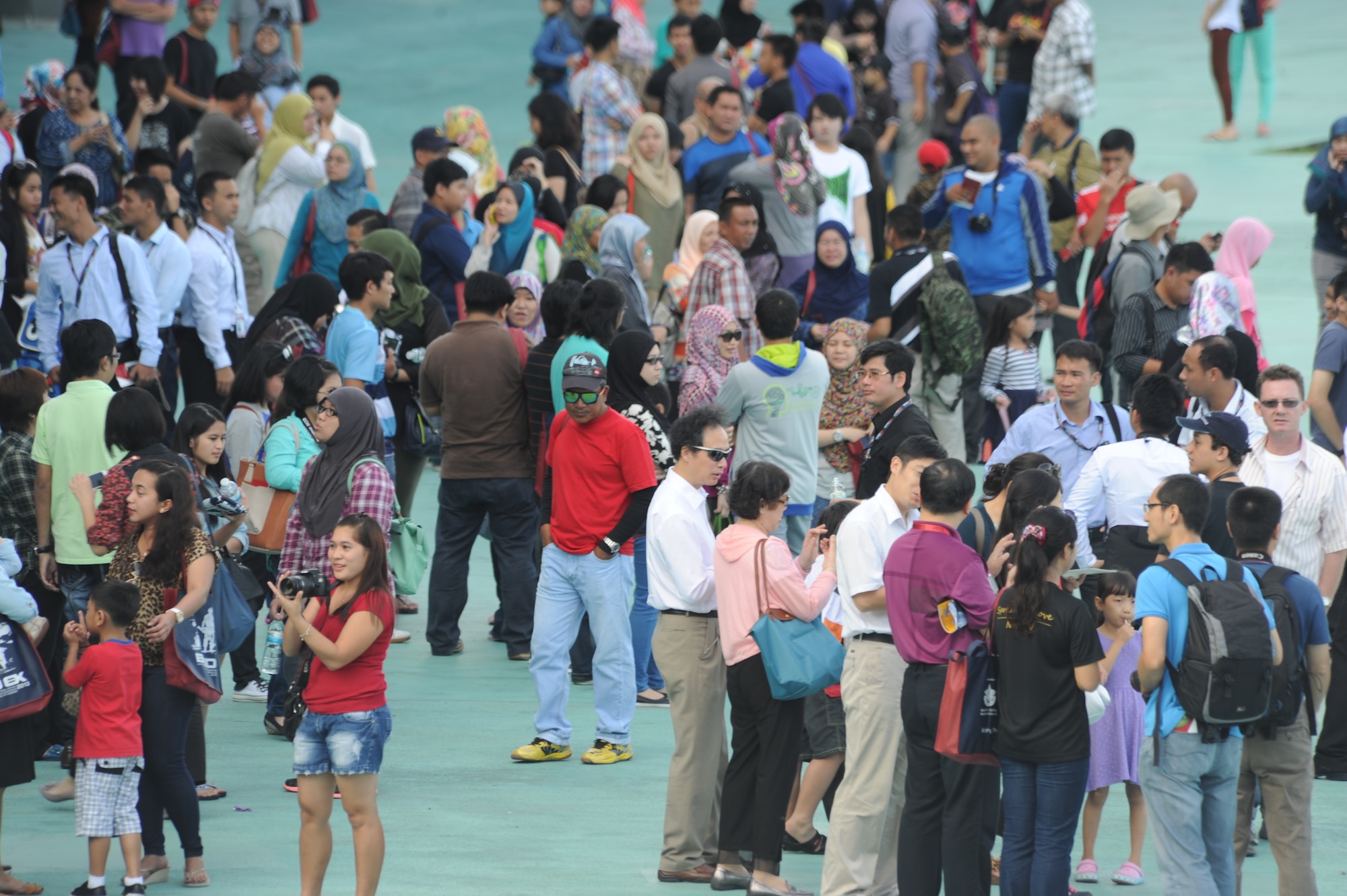 An assembled crowd of spectators patiently awaits the demonstration of various international military aircraft during the fourth biennial Brunei Darussalam International Defense Exhibition at the BRIDEX Exhibition Center in Bandar Seri Begawan, Brunei, Dec. 5, 2013. BRIDEX 13 is a five-day event compromised of social events, displays and demonstrations. BRIDEX 13 is an opportunity for networking and sharing technology with regional partners and allies which builds strong multilateral relationships, increases cooperation and enhances preparedness for disasters and other contingency operations. (U.S. Air Force photo/Master Sgt. Jerome S. Tayborn)
