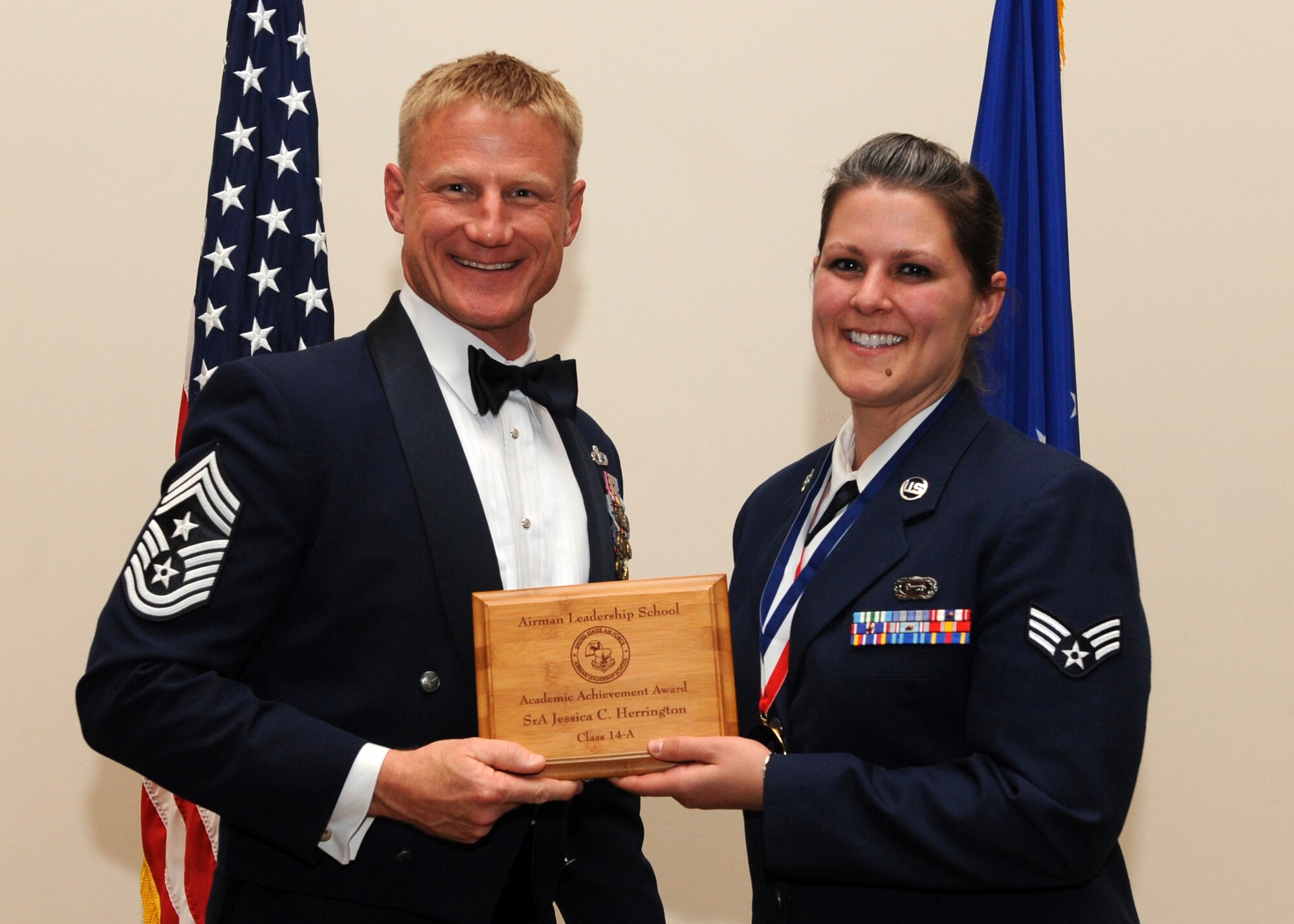 Chief Master Sgt. Craig Hall, 460th Space Wing command chief, presents Senior Airman Jessica C. Herrington, 566th Intelligence Squadron, right, the Academic Achievement Award during the Buckley Airman Leadership School Class 14-A graduation Dec. 4, 2013, at the Leadership Development Center on Buckley Air Force Base, Colo. The Academic Award is given to the student with the highest overall average score on all academic evaluations during ALS. (U.S. Air Force photo by Senior Airman Marcy Copeland/Released)