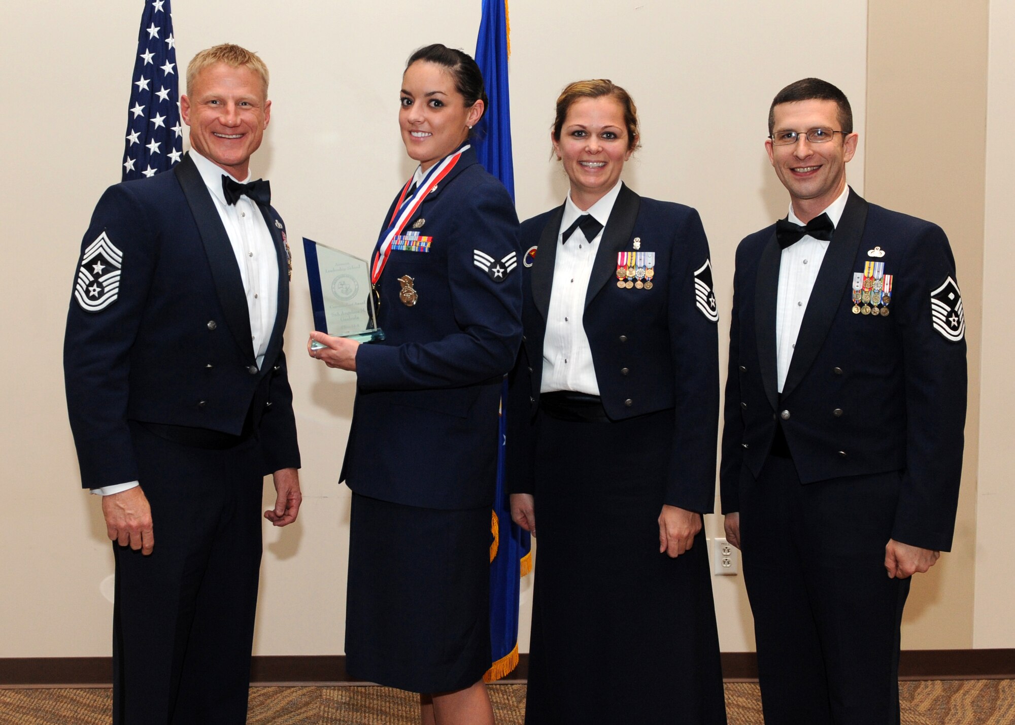Senior Airman Angelina M. Gazboda, 460th Security Forces Squadron, second from left, receives the Commandant Award during the Buckley Airman Leadership School Class 14-A graduation Dec. 4, 2013, at the Leadership Development Center on Buckley Air Force Base, Colo. The Commandant Award is presented to the student who displayed all the characteristics of an effective leader during ALS. (U.S. Air Force photo by Senior Airman Marcy Copeland/Released)
