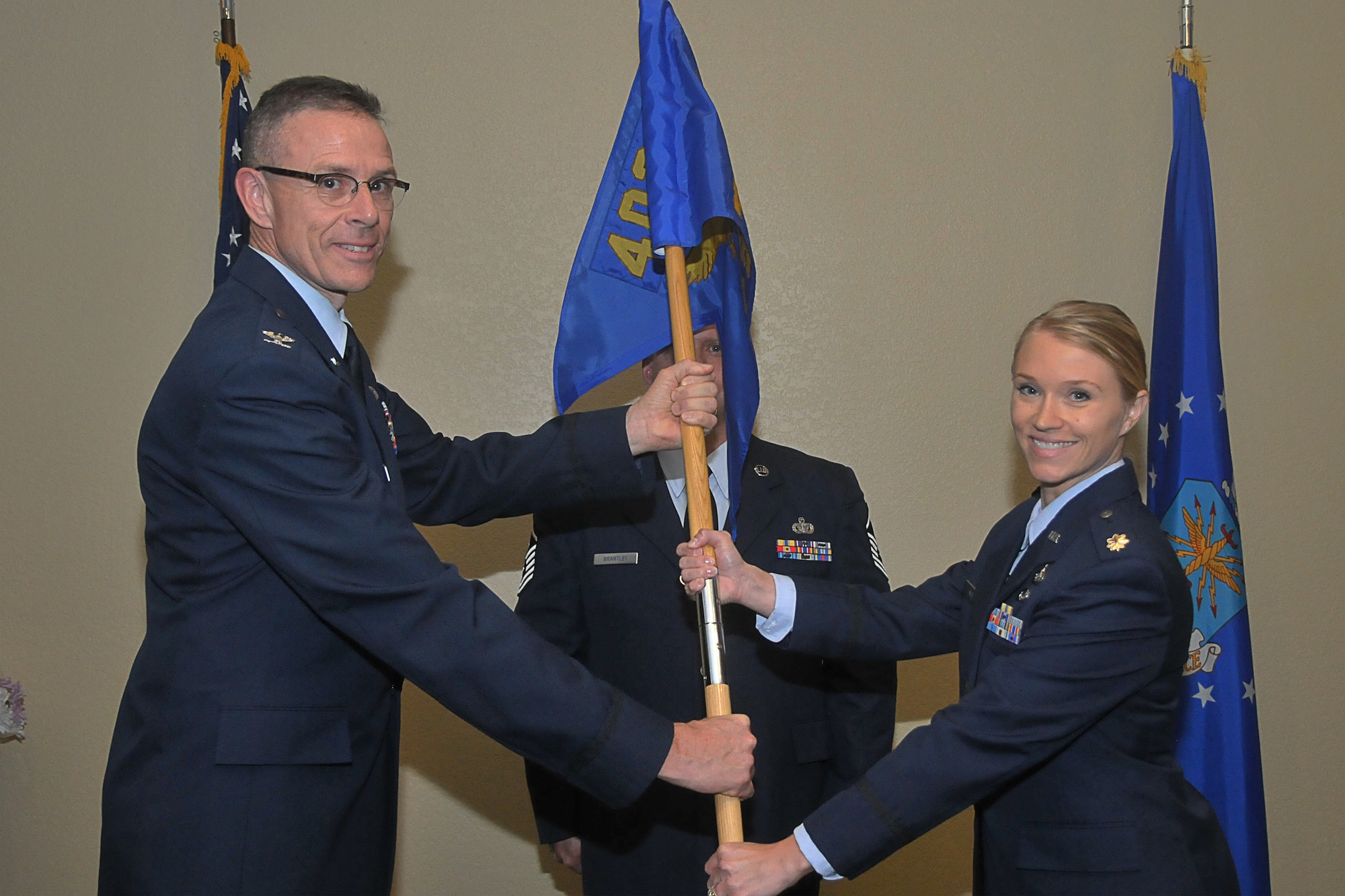 Maj. Salena M. Ingham receives the 403d Force Support Squadron guidon from Col. Kevin Riley, 403d Mission Support Group commander, during the change of command ceremony at the Bay Breeze Event Center Dec. 6, 2013. 