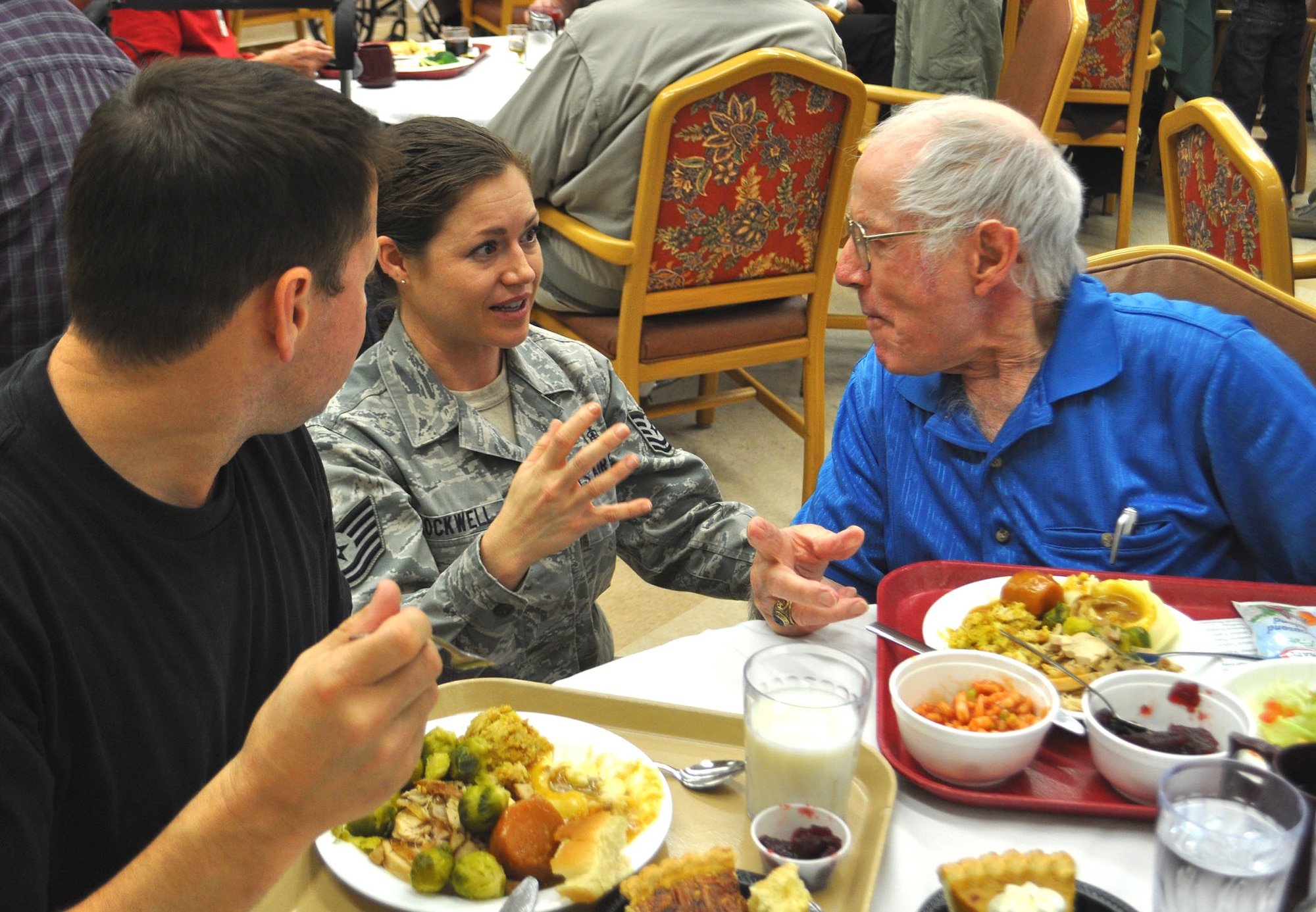 TRAVIS AIR FORCE BASE, Calif. -- Technical Sgt. Cameo Rockwell, 349th Civil Engineer Squadron, talks with a veteran at the California Veterans Home, Yountville,  on Thanksgiving Day. Rockwell joined a group of active and Reserve volunteers from Travis AFB, who spent some of their holiday serving the meal, and visiting with the veterans and their families. (U.S. Air Force photo/SMSgt. (ret) Ellen Hatfield)
