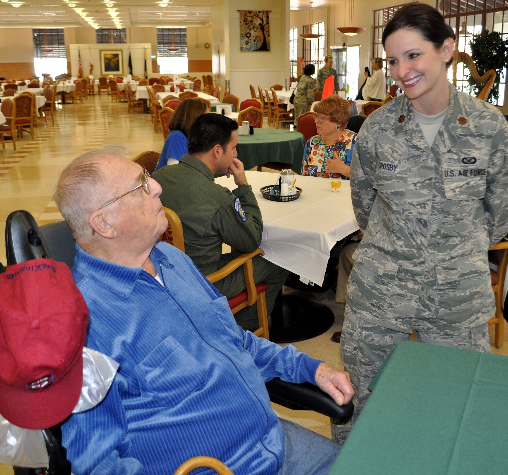 TRAVIS AIR FORCE BASE, Calif. -- Maj. Torri Crosby smiles as she listens to a story from a veteran over Thanksgiving dinner at the Yountville Veterans Home. She joined a group of Travis Airmen who volunteer yearly to spend part of their holiday with those who paved the way for those still in uniform. Crosby is the 349th AMW executive officer. (U.S. Air Force photo/SMSgt. (ret) Ellen Hatfield)
