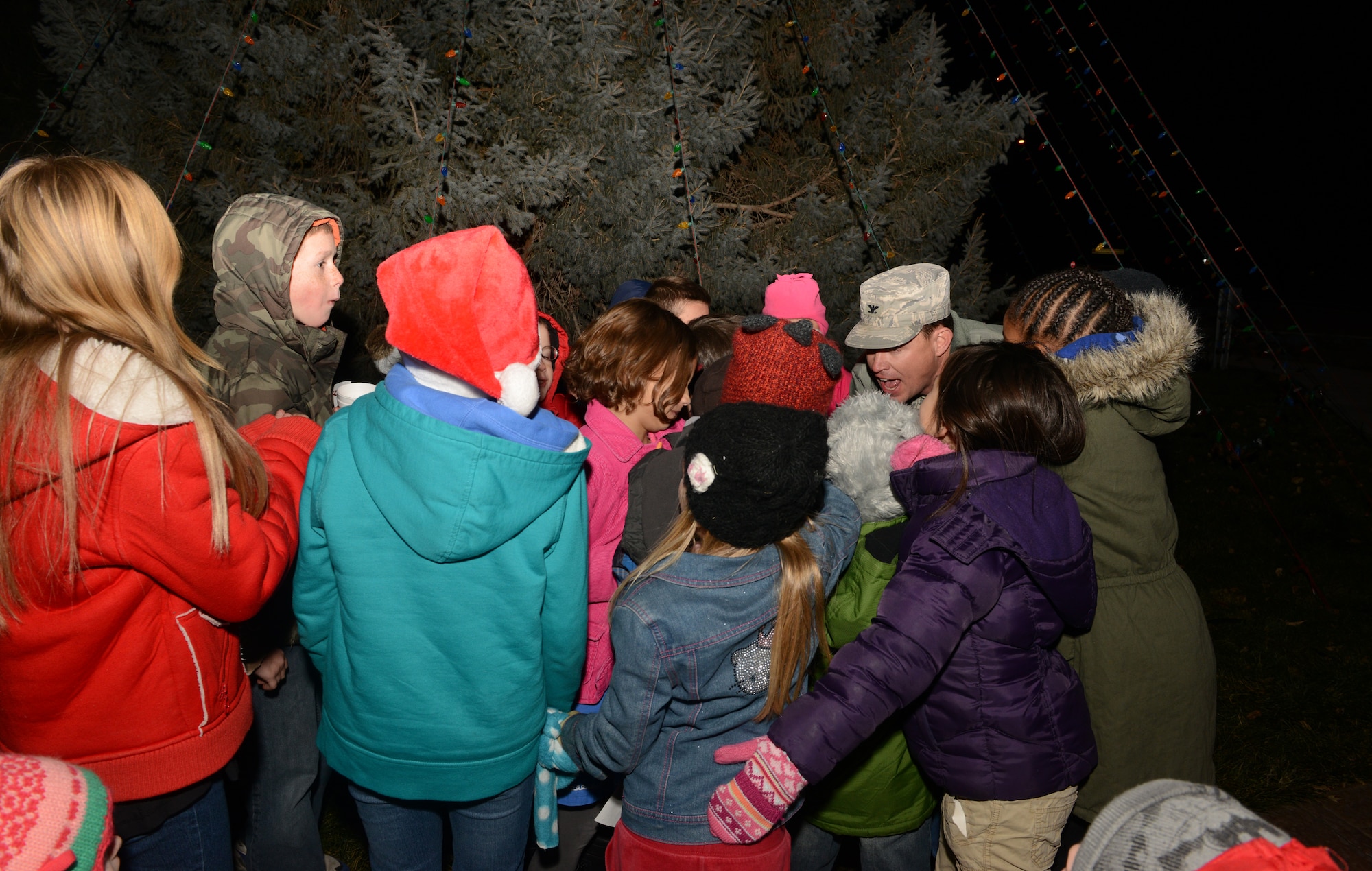 U.S Air Force Col. Byron Anderson, 366th vice commander, flips the Christmas Tree lights on with the Gunfighter children Dec. 5, 2013, at Mountain Home Air Force Base, Idaho. Children and their parents had the opportunity to meet Santa Claus and sing carols before the tree lighting ceremony. (U.S. Air Force photo by Airman 1st Class Malissa Lott/ Released)
