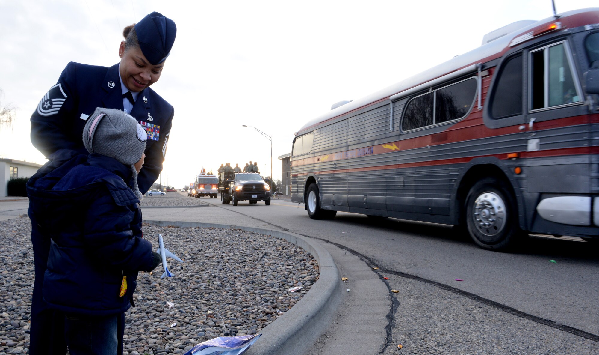 U.S. Air Force Master Sgt. Libra Joseph, 366th Fighter Wing knowledge operations manager wing functional, and her son, Collin Joseph Jr., watches the parade drive by at Mountain Home Air Force Base, Idaho, Dec. 5, 2013. Members of the parade handed out candy to base housing families. (U.S. Air Force photo by Airman 1st Class Malissa Lott/ Released)