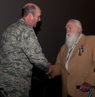 Col. Trevor Flint, 90th Maintenance Group commander, shakes hands with 1st Lt. (Ret.) Paul Kniss after a medal presentation ceremony. Kniss was presented the Purple Heart medal and Prisoner of War medal he wears on his lapel in the F.E. Warren Air Force Base, Wyo., Theater Dec. 5, 2013. After the ceremony, droves of attendees lined up for the opportunity to congratulate, thank and shake hands with Kniss. Approximately 400 people attended the ceremony (U.S. Air Force photo by Airman 1st Class Jason Wiese)