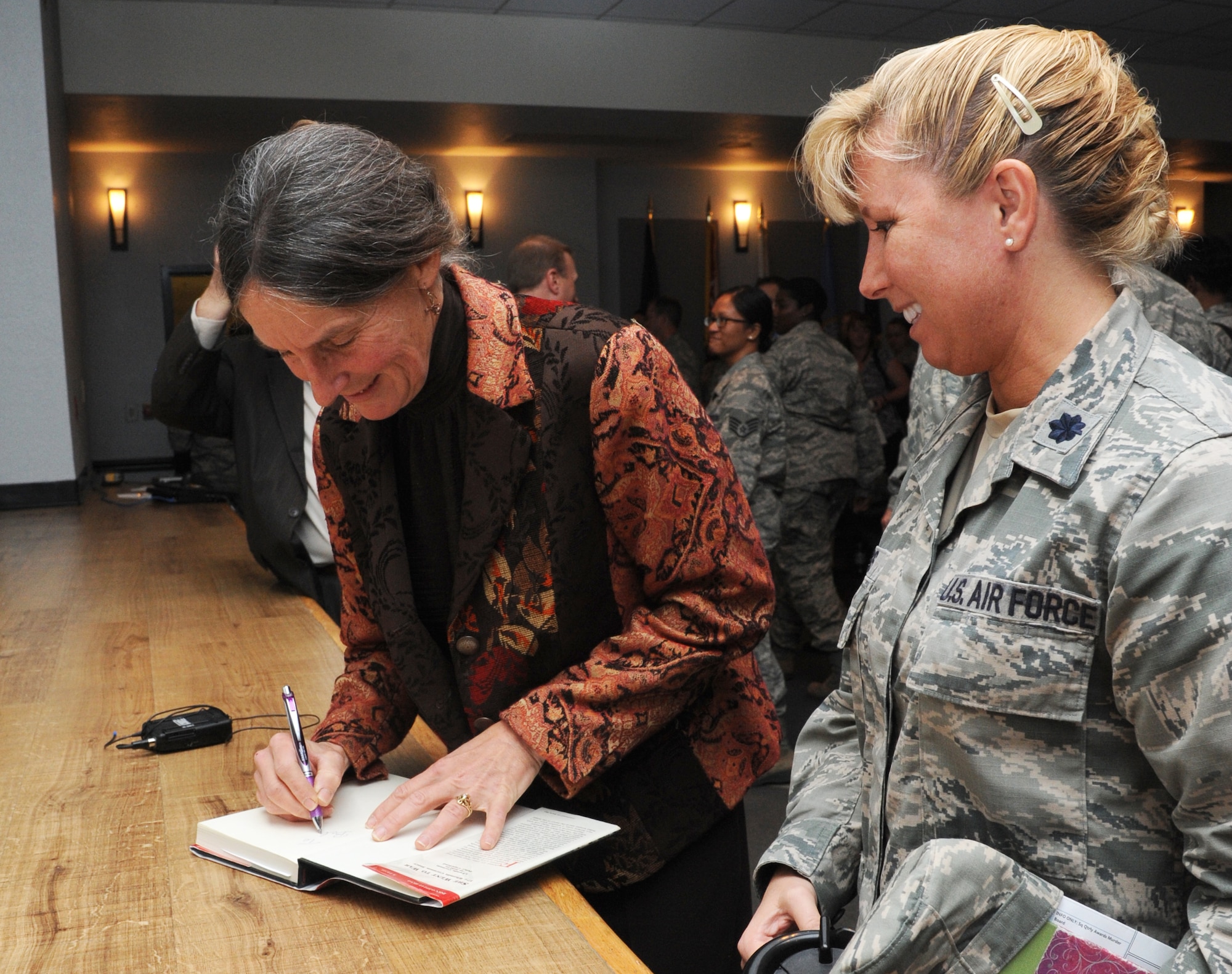 Retired Army Brig. Gen. Rhonda Cornum autographs a book she wrote about her experience as a prisoner of war in Iraq in 1991 for Lt. Col. Dorene Ross, 335th Training Squadron commander, Dec. 5, 2013, at the Keesler Medical Center.  During the Persian Gulf War, Cornum’s helicopter was shot down while on a search and rescue mission. She suffered two broken arms, a gunshot wound in the back and was captured by enemy forces. Cornum is the wife of Brig. Gen. Kory Cornum, 81st Medical Group commander. (U.S. Air Force photo by Kemberly Groue)