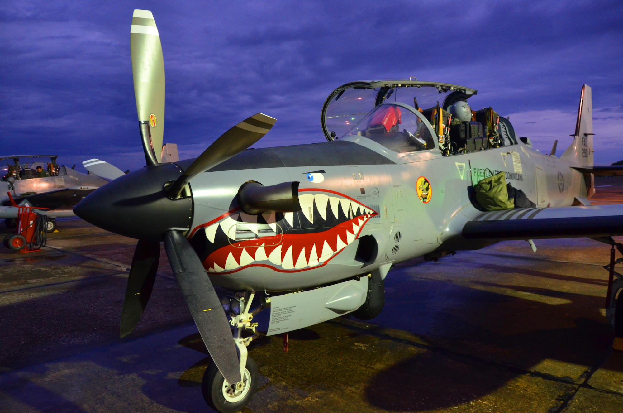 A Dominican Republic air force A-29 pilot inspects his aircraft for a nighttime flight as part of an exercise to detect and track illegal drug traffic Dec. 4, 2013. The exercise is part of the Sovereign Skies Program, an initiative between the U.S., Colombian, and Dominican Republic air forces to share best-practices on procedures to detect, track and intercept illegal drugs moving north from South America. Since the program’s inception, the number of aircraft suspected to traffic drugs through the Dominican Republic dropped from more than 100 annually to nearly zero. (U.S. Air Force photo by Capt. Justin Brockhoff/Released)


