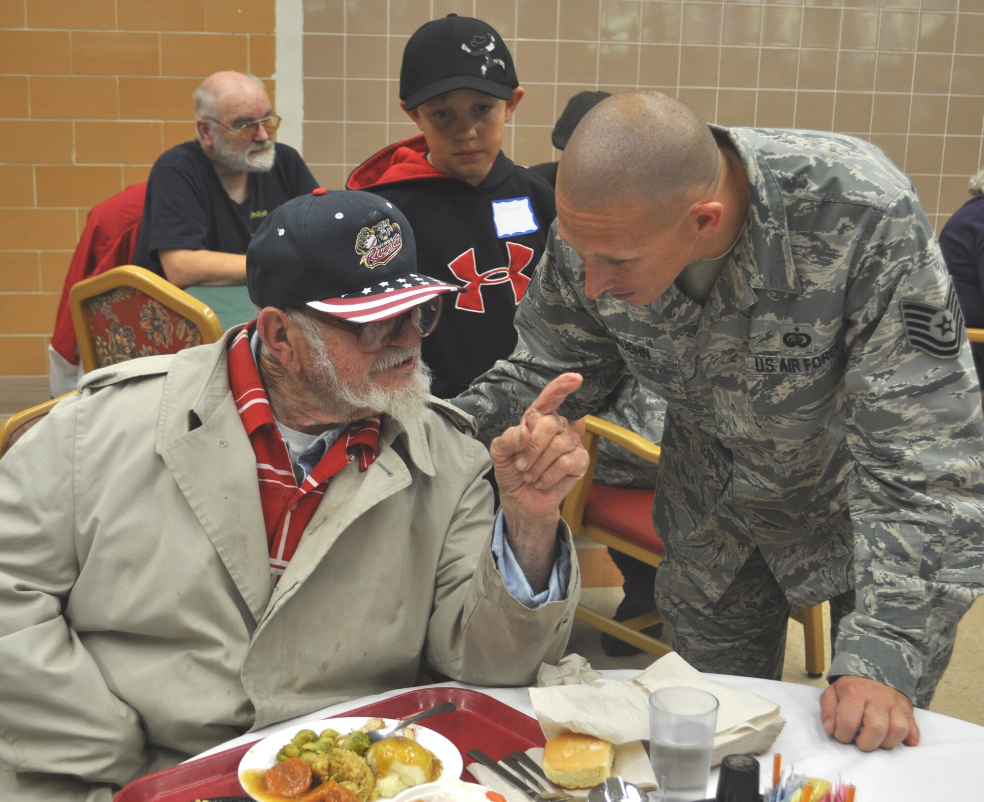 Technical Sgt. Brian Vaughn, 60th Medical Group, listens to one of the veterans at the Yountville Veterans Home, tell his story over Thanksgiving dinner.  (U.S. Air Foce photo/Ellen Hatfield)