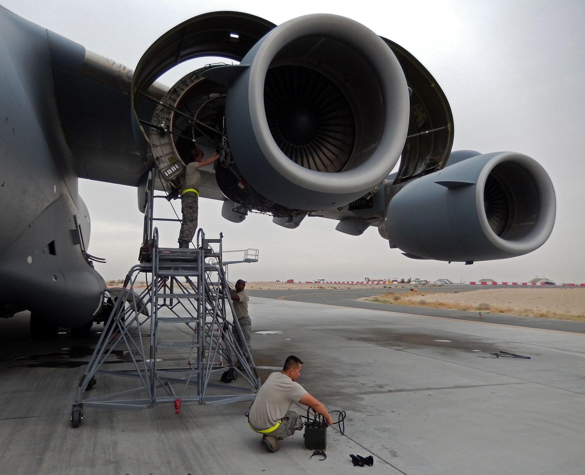 Airmen fromt he 5th Expeditionary Air Mobility Squadron conduct maintenance operations on a C-17 Globemaster III while deployed in Southwest Asia. The deployed Airmen are reservists from the 945th Aircraft Maintenance Squadron at Travis Air Force Base, Calif. (Courtesy 