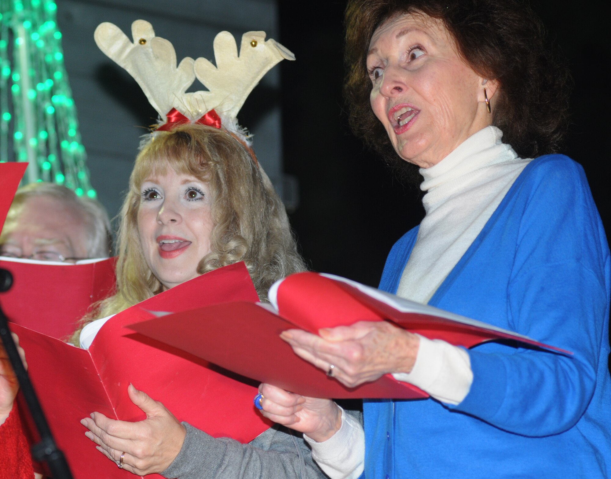 Roseanne Johnson-Fazo and Lounelle Draper, members of the Gulf Coast Messiah Chorus, sing during Keesler’s annual Christmas in the Park celebration Dec. 4, 2013, at marina park, Keesler Air Force Base, Miss. The event, hosted by Outdoor Recreation, included a tree lighting ceremony, tour train rides, cookie decorating, visits with Santa and free food and beverages. (U.S. Air Force photo by Kemberly Groue)