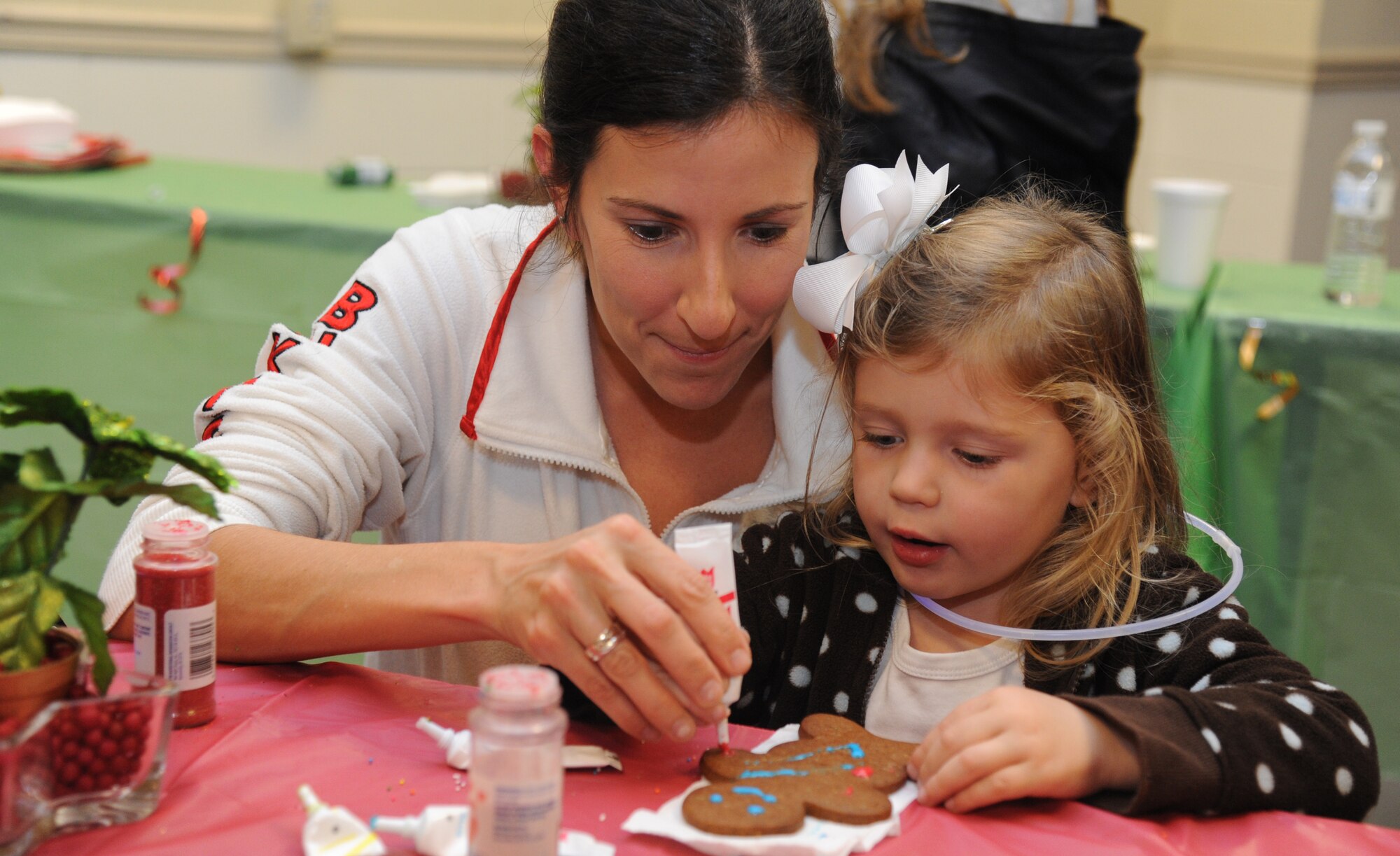 Lisa Campbell, 81st Force Support Squadron, helps her daughter decorate a ginger bread cookie during Keesler’s annual Christmas in the Park celebration Dec. 4, 2013, at marina park, Keesler Air Force Base, Miss. The event, hosted by Outdoor Recreation, included a tree lighting ceremony, tour train rides, holiday music, visits with Santa and free food and beverages. (U.S. Air Force photo by Kemberly Groue)