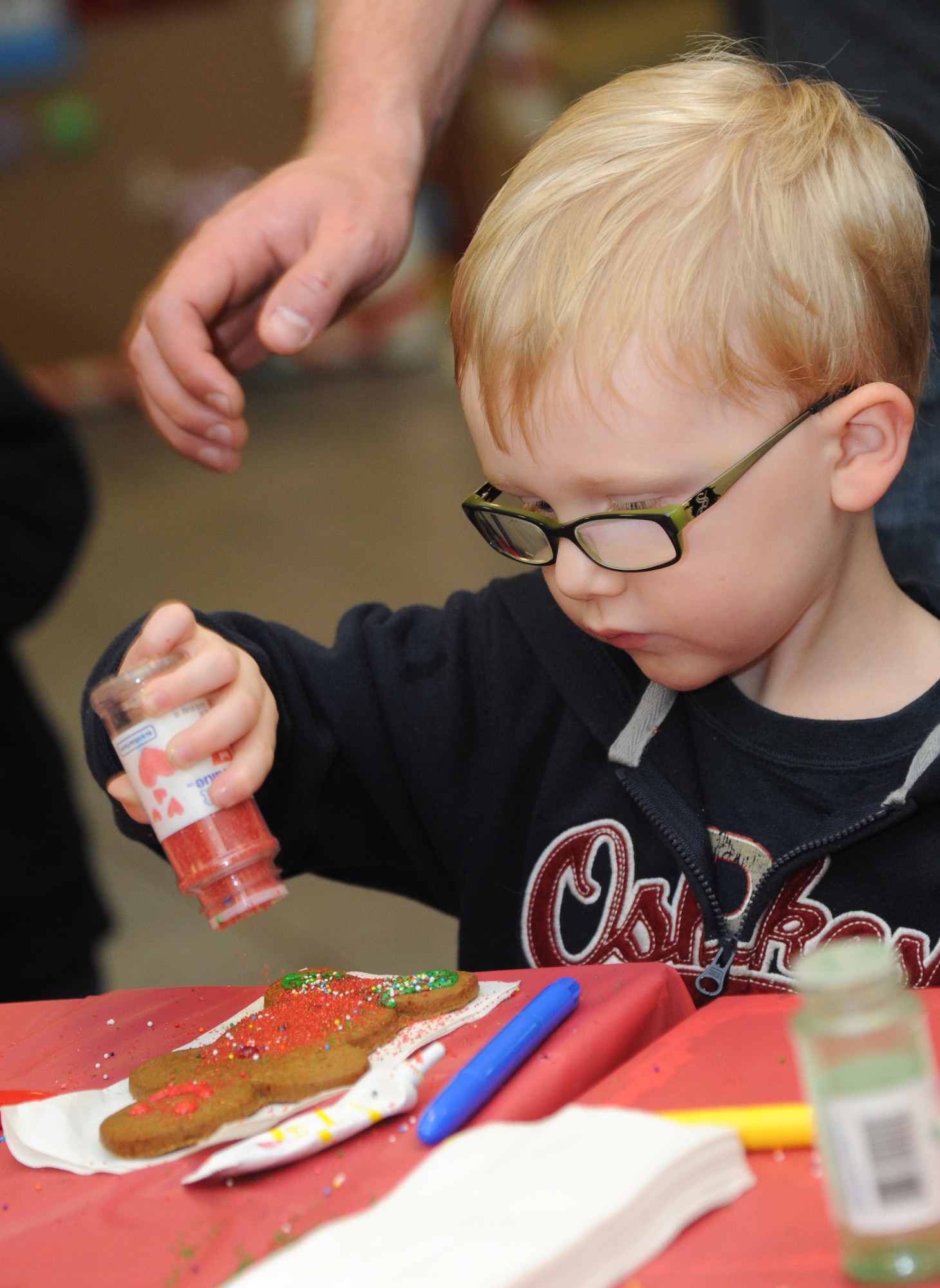 The son of Sgt. Christopher Smith, Keesler Marine Detachment, decorates a ginger bread cookie during Keesler’s annual Christmas in the Park celebration Dec. 4, 2013, at marina park, Keesler Air Force Base, Miss. The event, hosted by Outdoor Recreation, included a tree lighting ceremony, tour train rides, holiday music, visits with Santa and free food and beverages. (U.S. Air Force photo by Kemberly Groue)