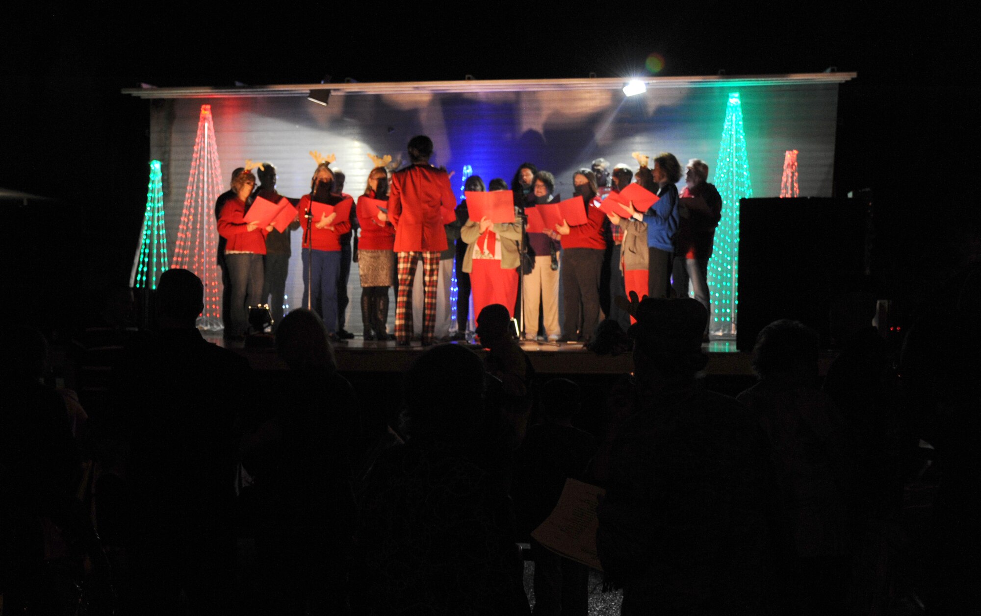 Members of the Gulf Coast Messiah Chorus, sing holiday songs during Keesler’s annual Christmas in the Park celebration Dec. 4, 2013, at marina park, Keesler Air Force Base, Miss. The event, hosted by Outdoor Recreation, included a tree lighting ceremony, tour train rides, cookie decorating, visits with Santa and free food and beverages.  (U.S. Air Force photo by Kemberly Groue)