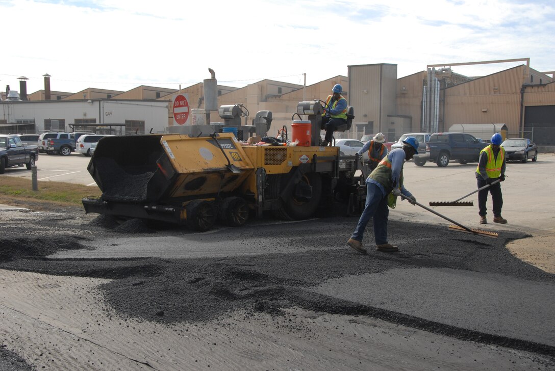 Contractors lay asphalt between Ninth Street and Eleventh Street. Road construction on base is planned to continue into January. (U.S. Air Force photo by Misuzu Allen)
