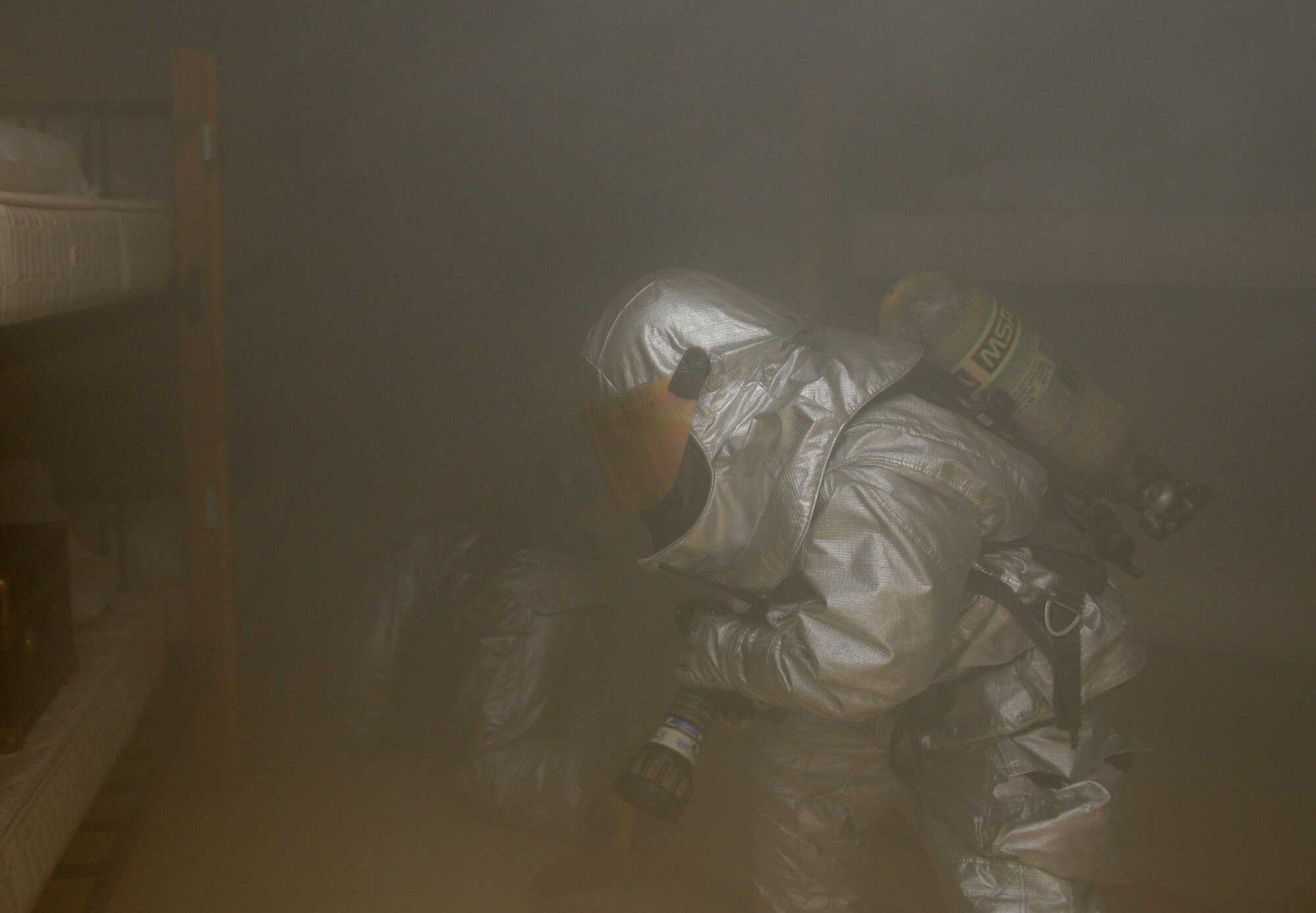 Members of the 379th Expeditionary Civil Engineer Squadron search a room for casualties during a fire attack and search and rescue tactics exercise at the 379th Air Expeditionary Wing in Southwest Asia, Dec. 5, 2013.  The 379th ECES fire department conducts monthly training to keep crews proficient, safe and ready to handle any fire-related situation. (U.S. Air Force photo/Senior Airman Hannah Landeros)