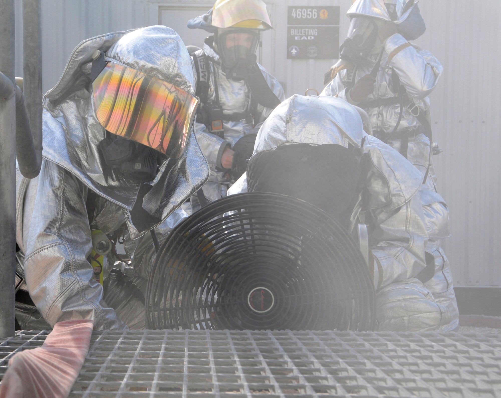 Members of the 379th Expeditionary Civil Engineer Squadron fan smoke out of a simulated burning building during a fire attack and search and rescue tactics exercise at the 379th Air Expeditionary Wing in Southwest Asia, Dec. 5, 2013.  The 379th ECES fire department conducts monthly training to keep crews proficient, safe and ready to handle any fire-related situation. (U.S. Air Force photo/Senior Airman Hannah Landeros)

