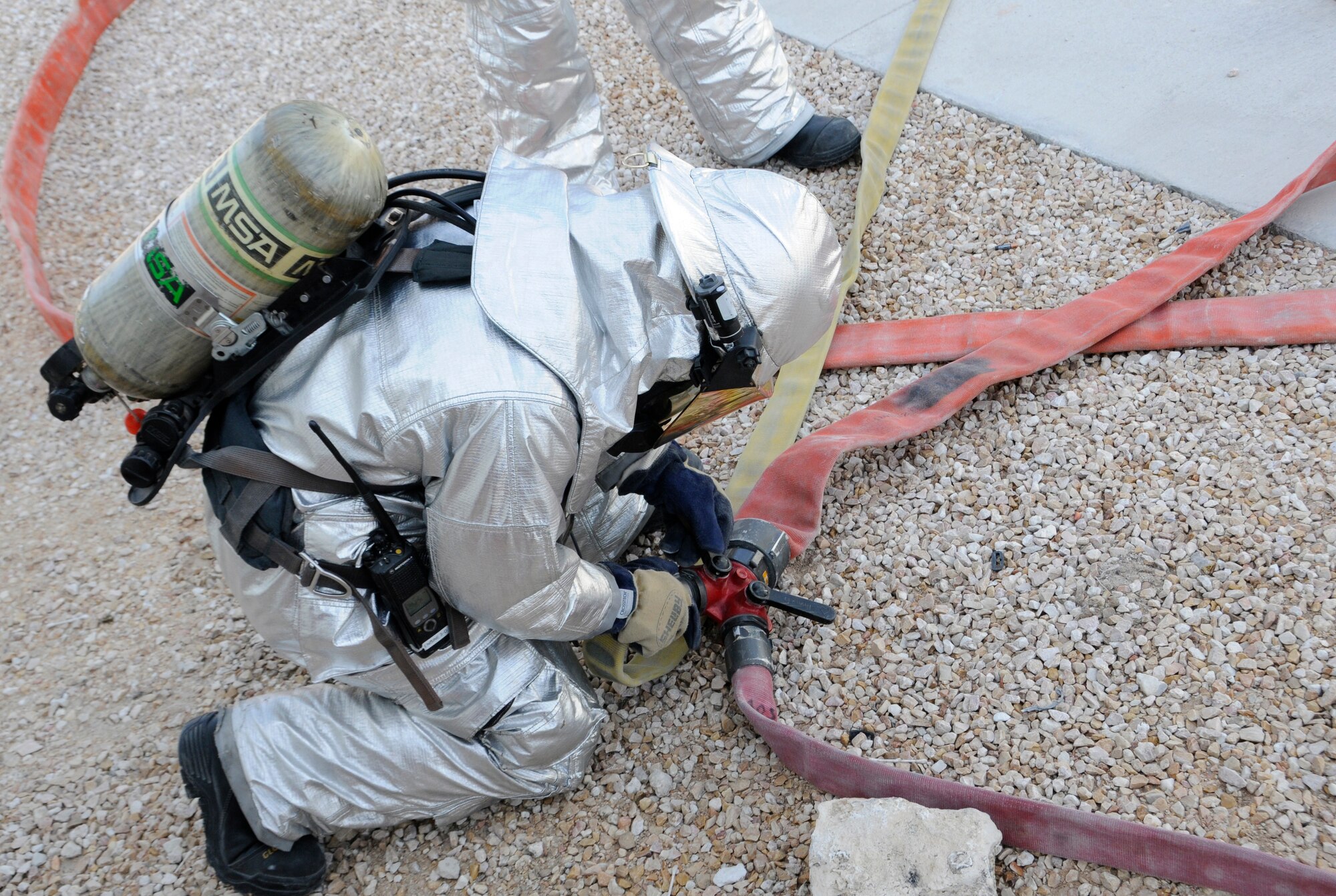 A member of the 379th Expeditionary Civil Engineer Squadron connects hose lines during a fire attack and search and rescue tactics exercise at the 379th Air Expeditionary Wing in Southwest Asia, Dec. 5, 2013.  The 379th ECES fire department conducts monthly training to keep crews proficient, safe and ready to handle any fire-related situation. (U.S. Air Force photo/Senior Airman Hannah Landeros)