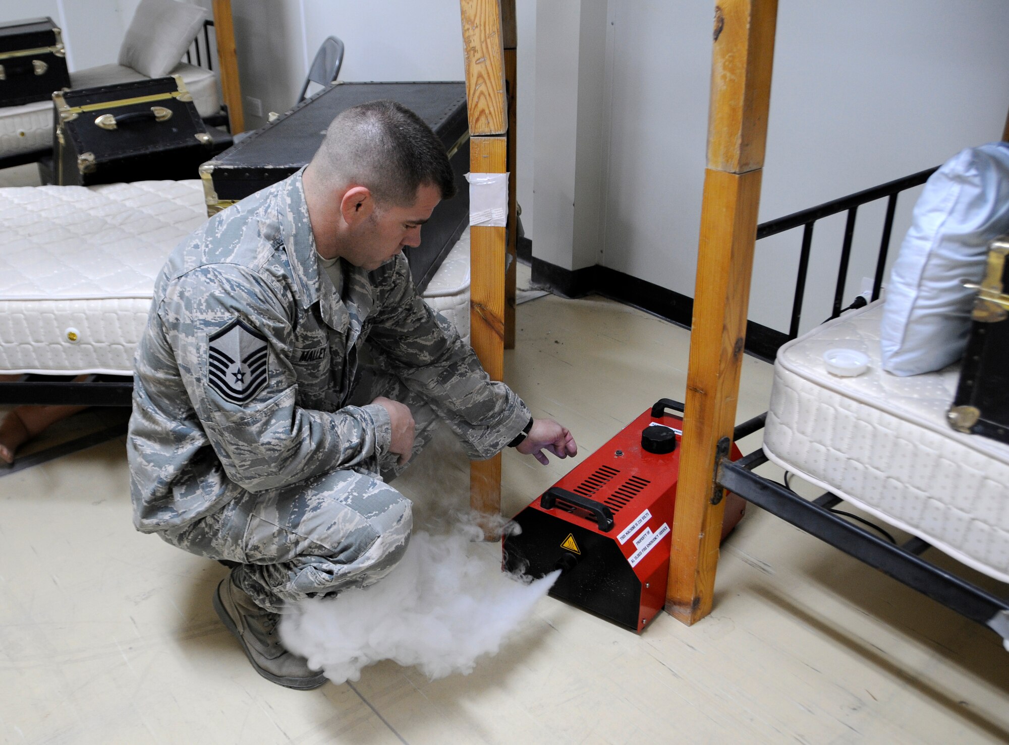 Master Sgt. Chad Malley fills a room with smoke before a fire attack and search and rescue tactics exercise at the 379th Air Expeditionary Wing in Southwest Asia, Dec. 5, 2013. The 379th Expeditionary Civil Engineer Squadron fire department conducts monthly training to keep crews proficient, safe and ready to handle any fire-related situation. Malley a Malone, N.Y. native, is 379th ECES, assistant chief of training and health and safety officer, deployed from Patrick Air Force Base, Fla. (U.S. Air Force photo/Senior Airman Hannah Landeros)